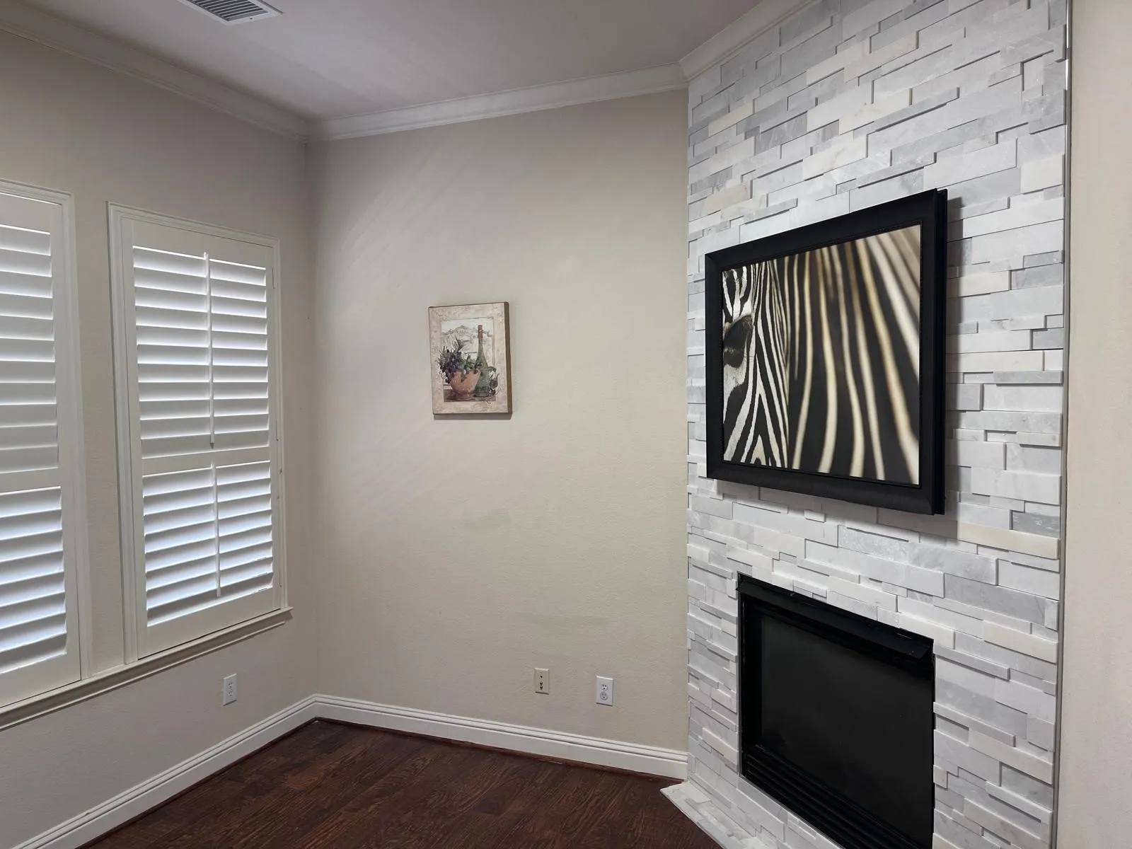 Corner fireplace featuring a stacked stone surround and black firebox