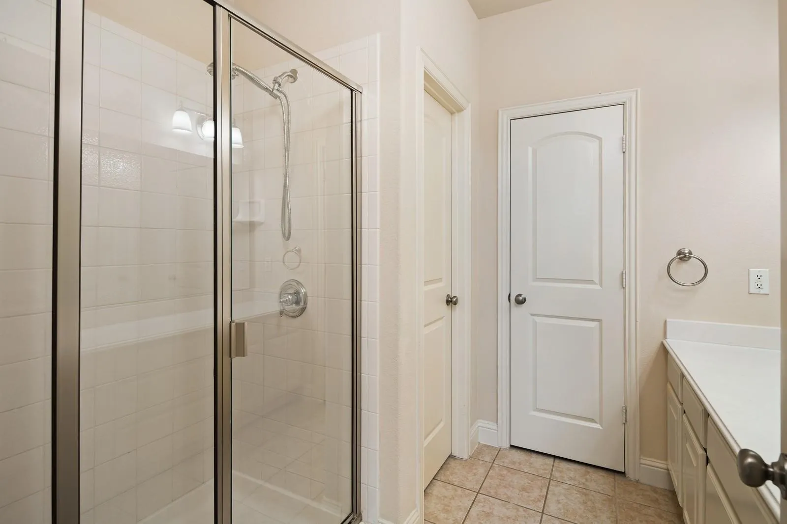 Glass-enclosed shower with white subway tile surround, built-in bench, and wall-mounted showerhead