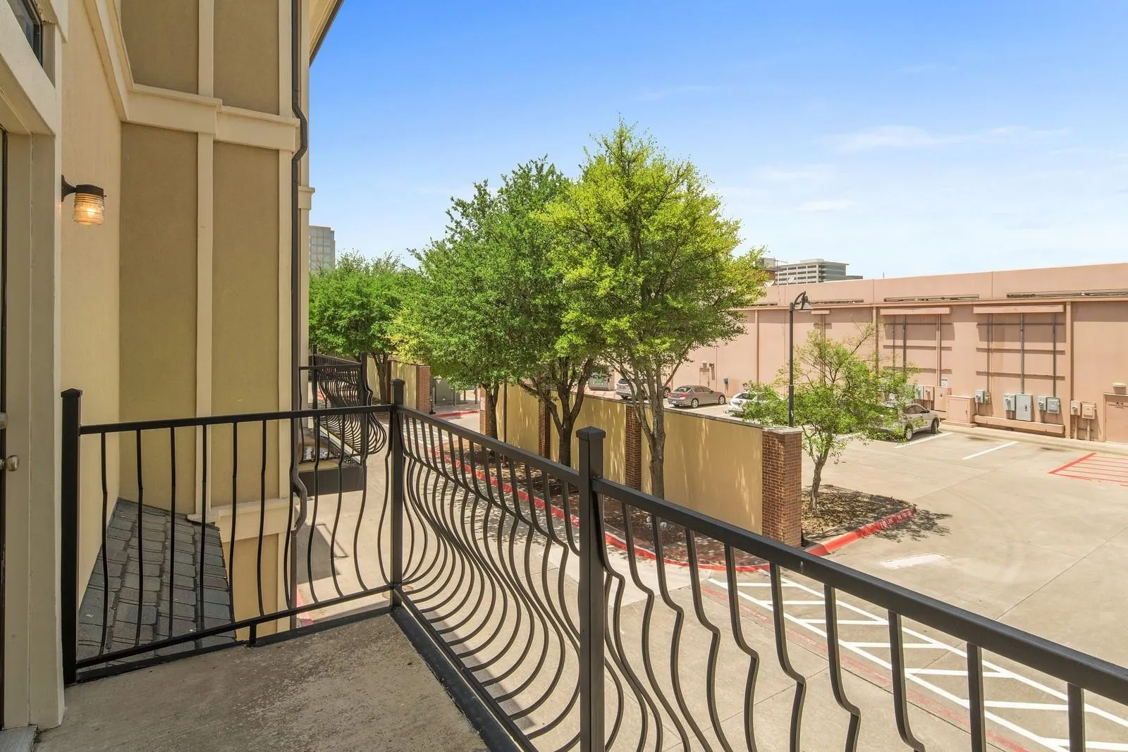 Private balcony featuring a concrete floor and decorative black wrought iron railing