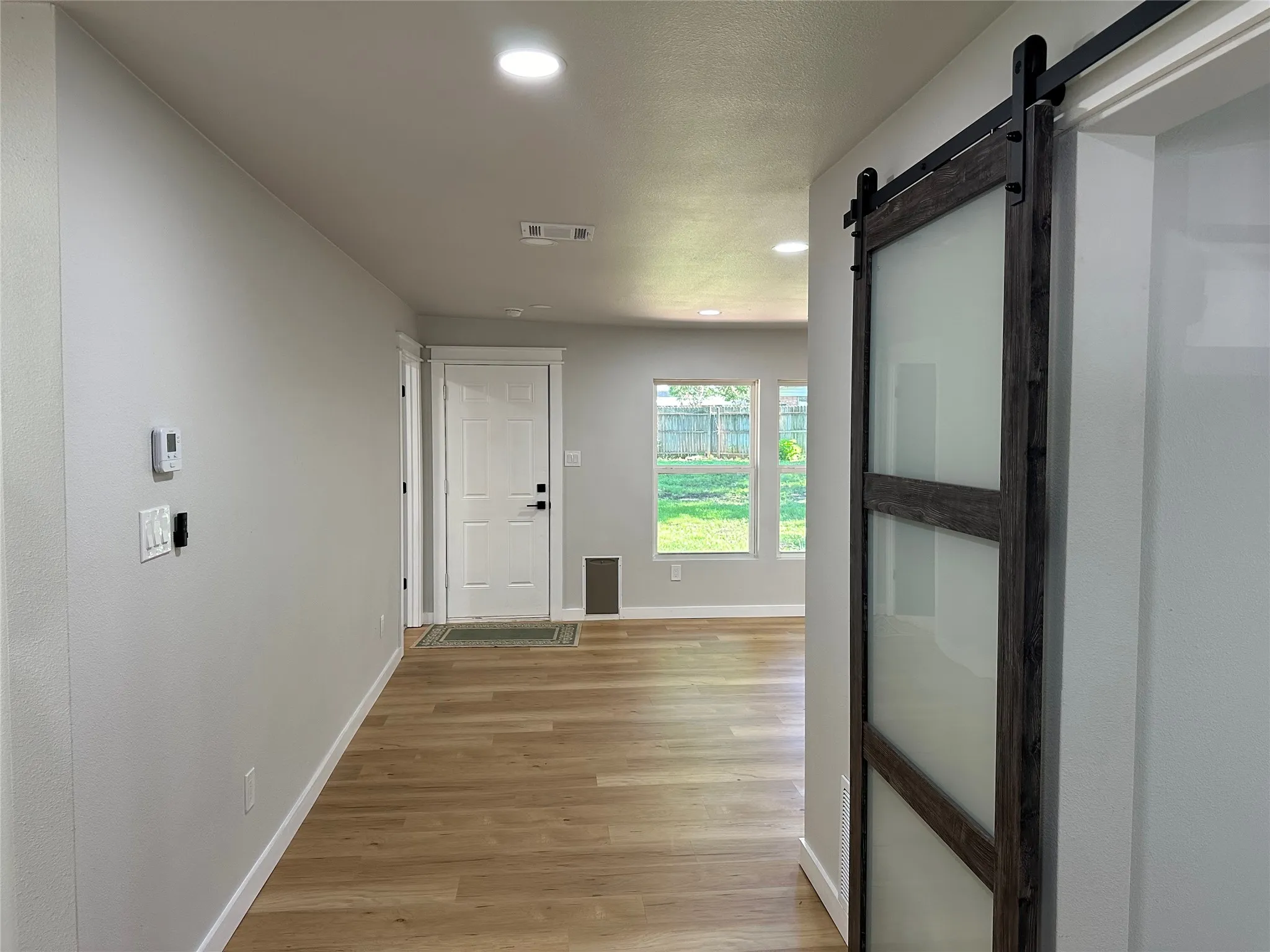 Hall featuring a barn door and light hardwood / wood-style flooring