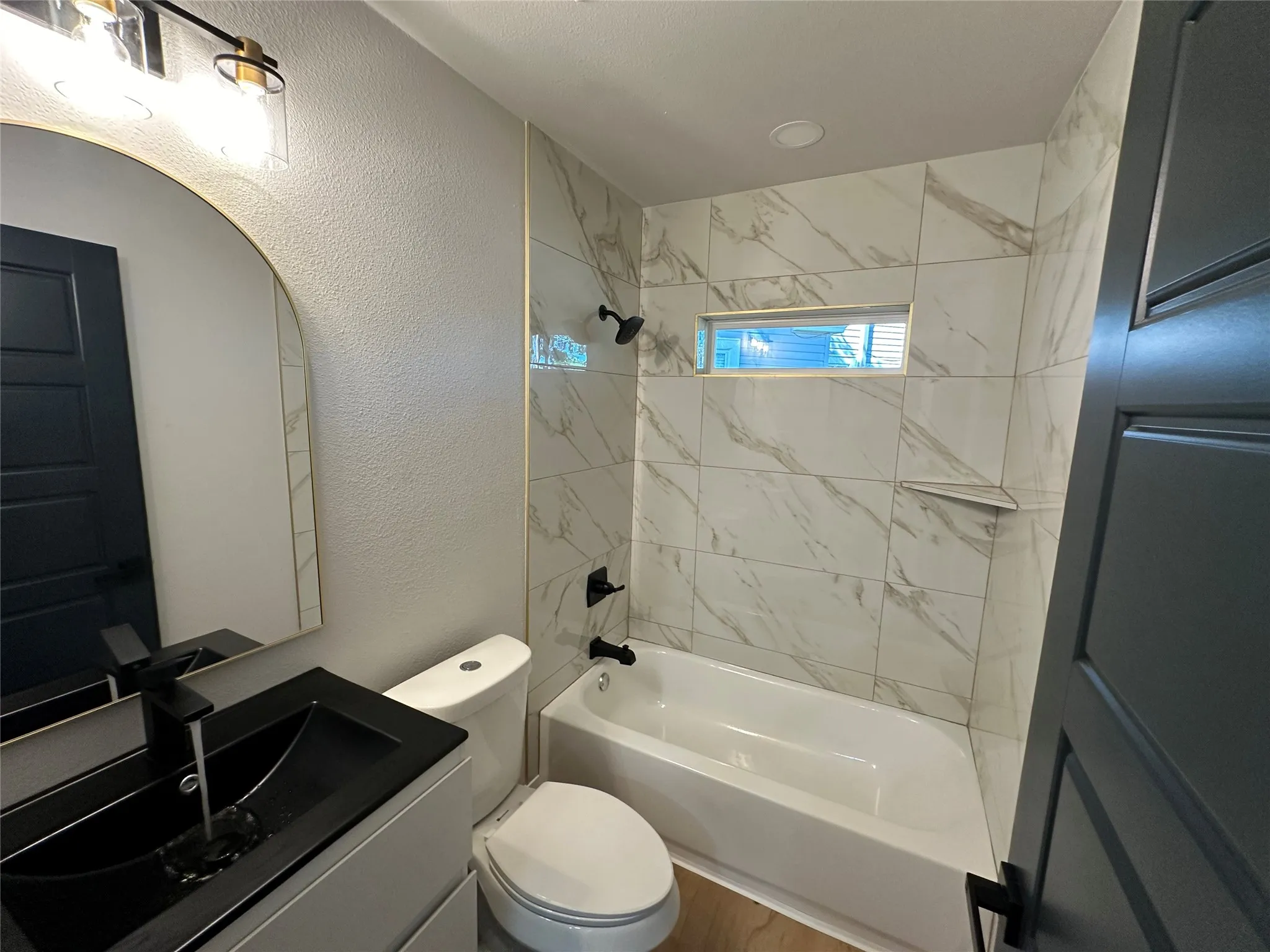 Full bathroom with vanity, toilet, and tiled shower / bath combo