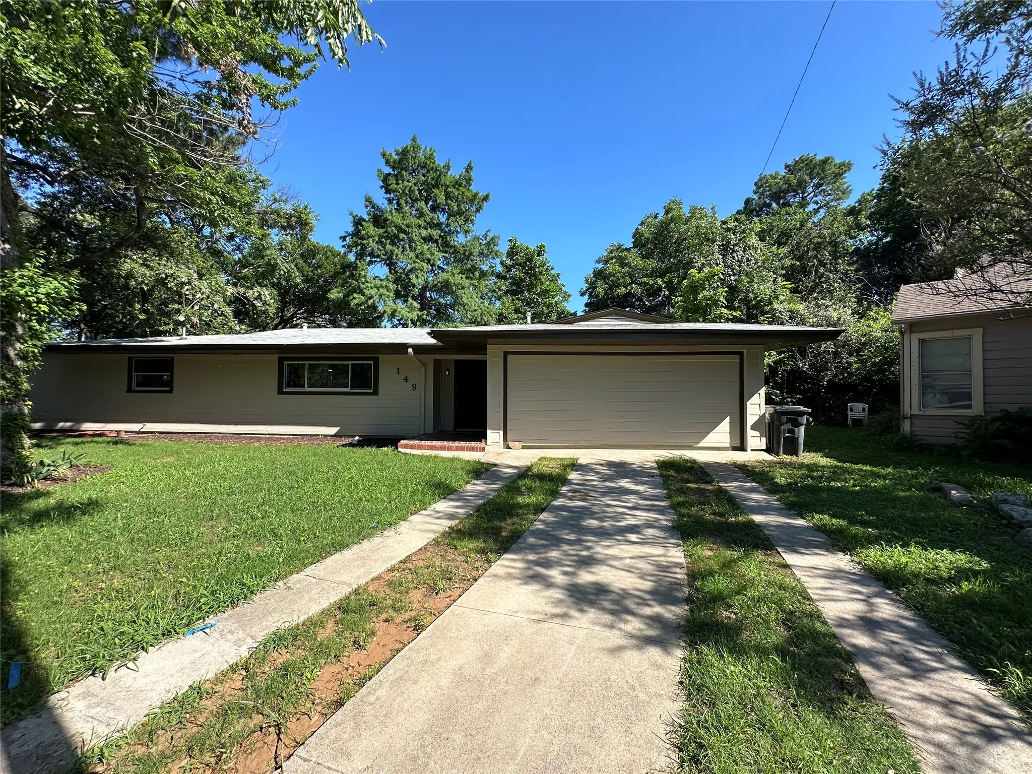 Ranch-style home with a garage and a front lawn