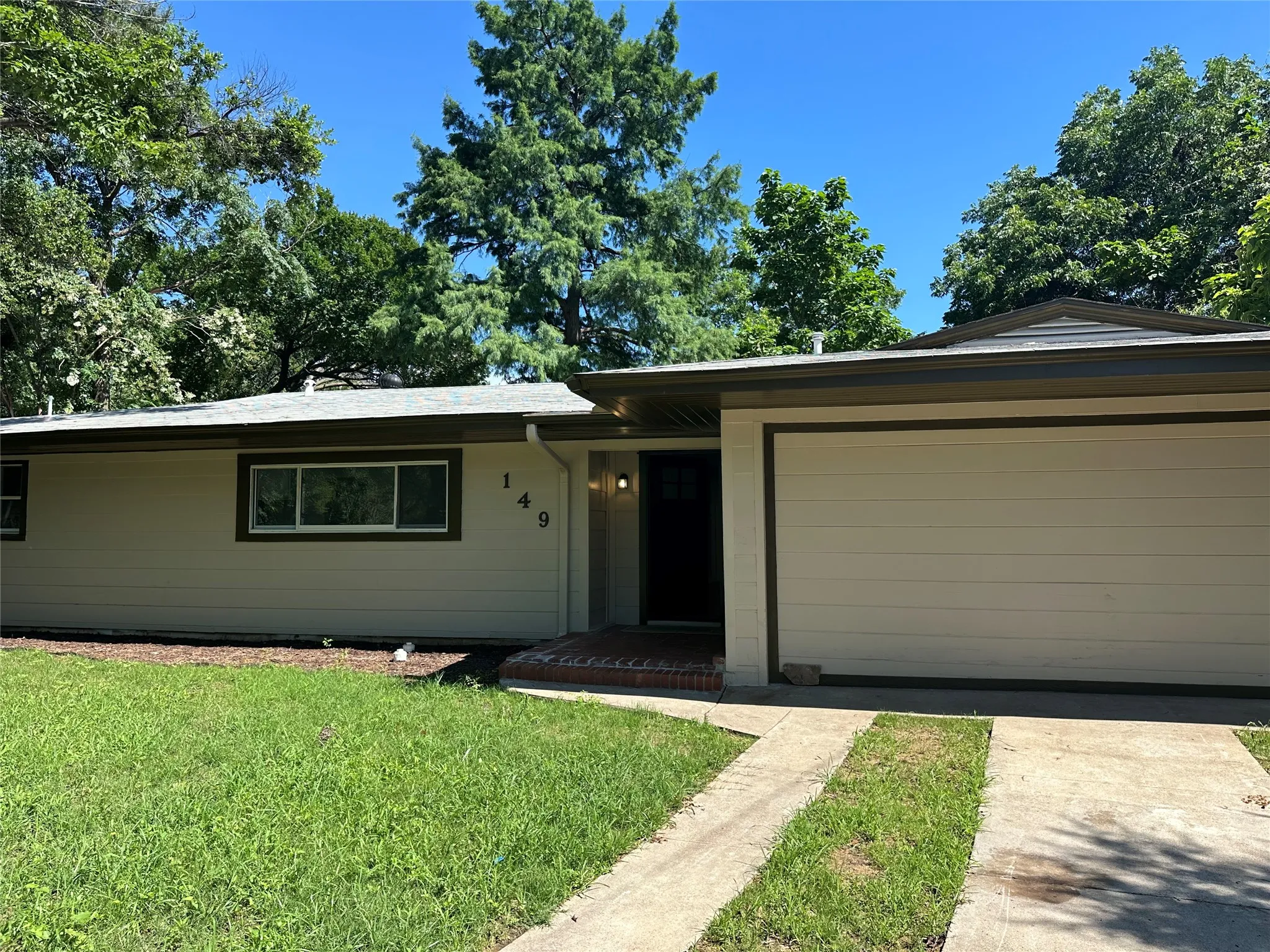 Single story home featuring a front lawn and a garage