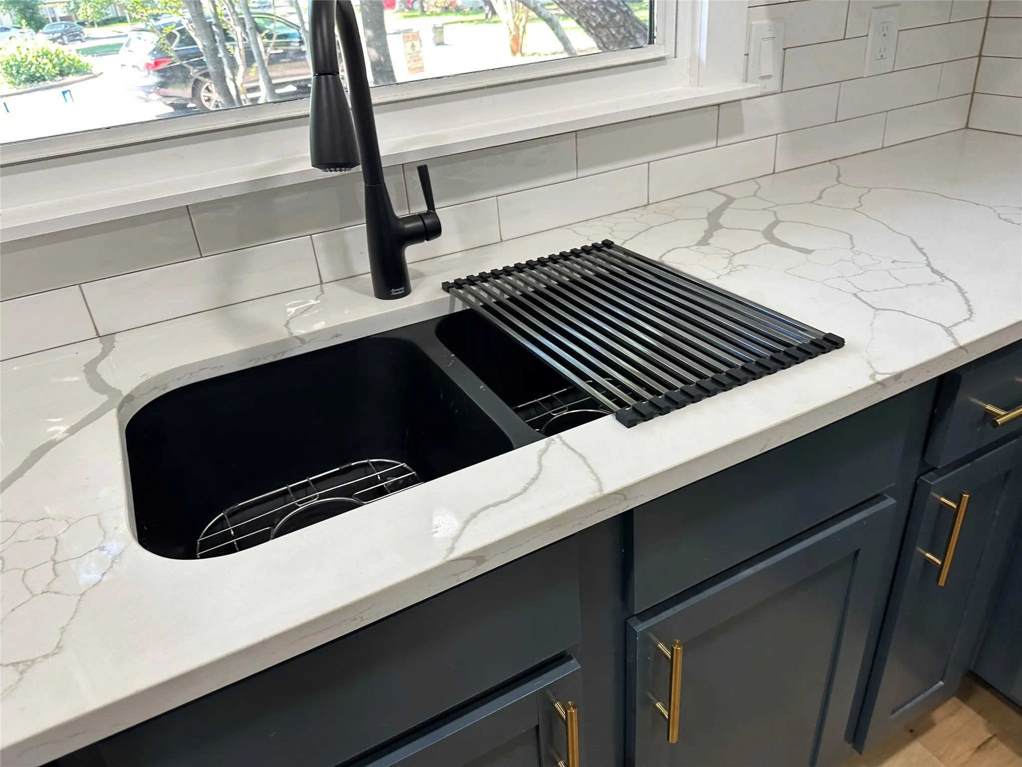 Details featuring light hardwood / wood-style floors, gray cabinetry, light stone counters, sink, and tasteful backsplash
