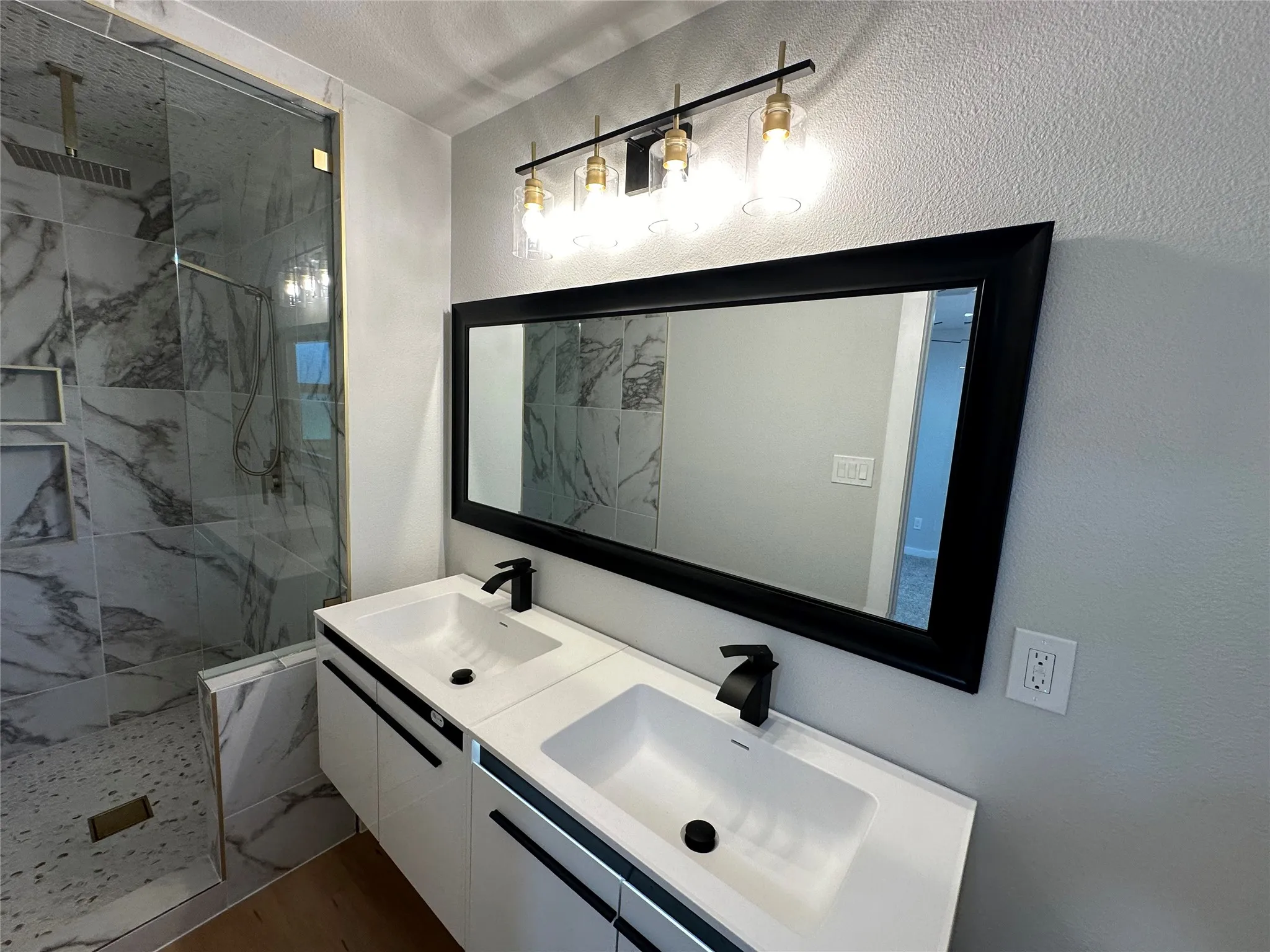 Bathroom featuring a tile shower and double sink vanity
