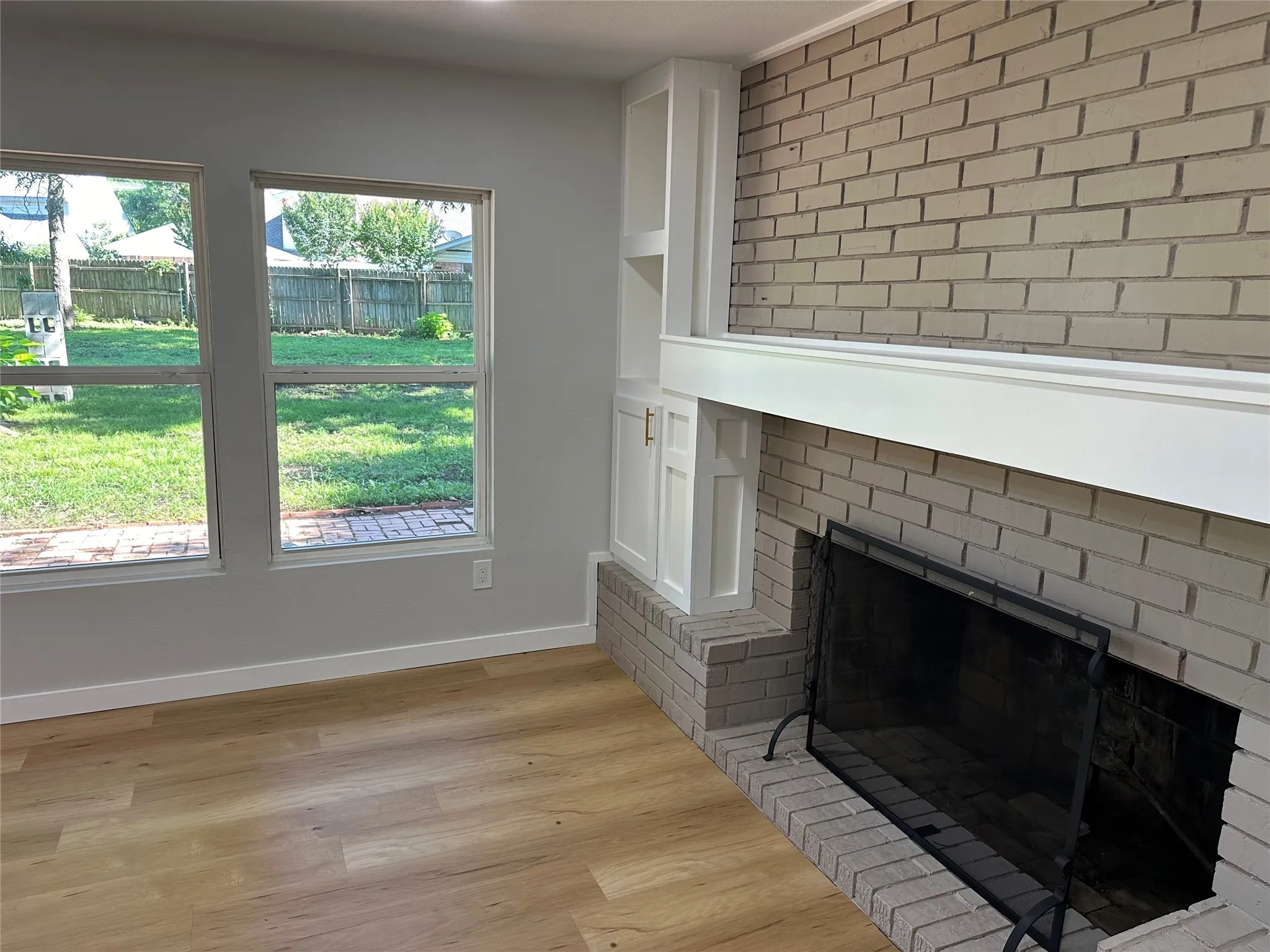 Unfurnished living room featuring a healthy amount of sunlight, light hardwood / wood-style flooring, and a fireplace