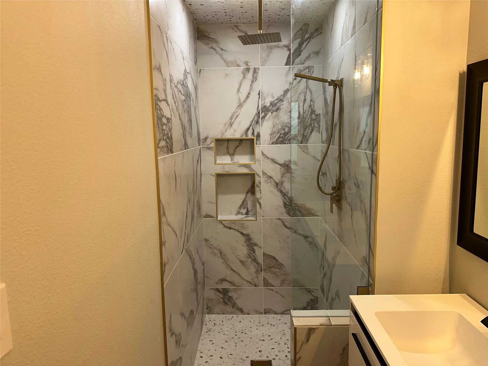 Bathroom with tiled shower and vanity
