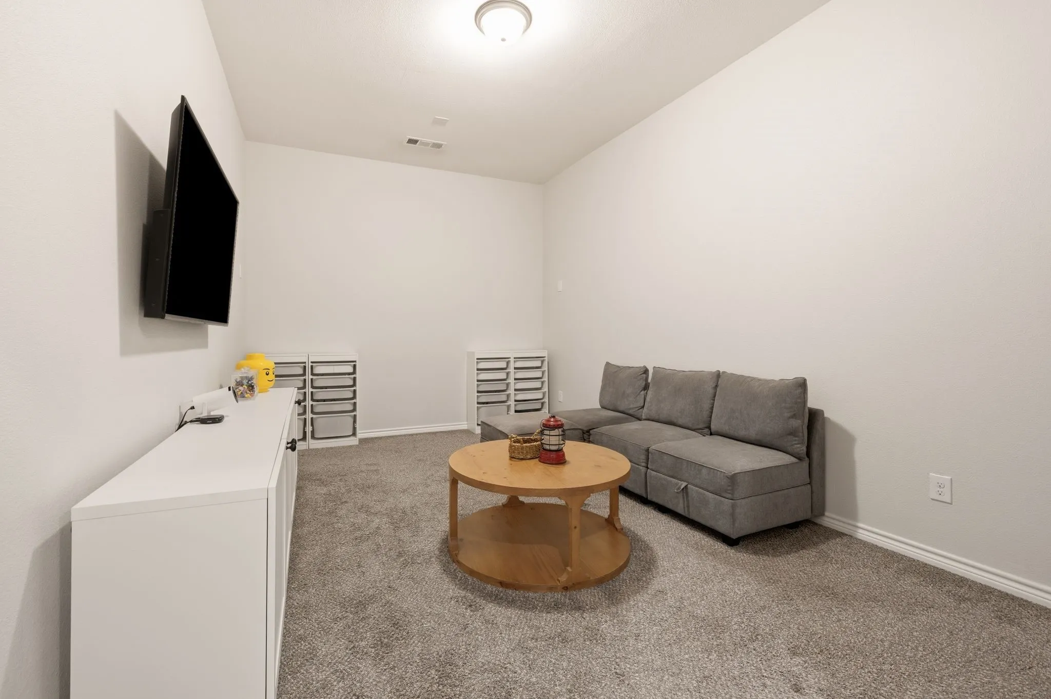 Spacious room featuring vaulted ceilings, recessed lighting, and soft gray carpeting