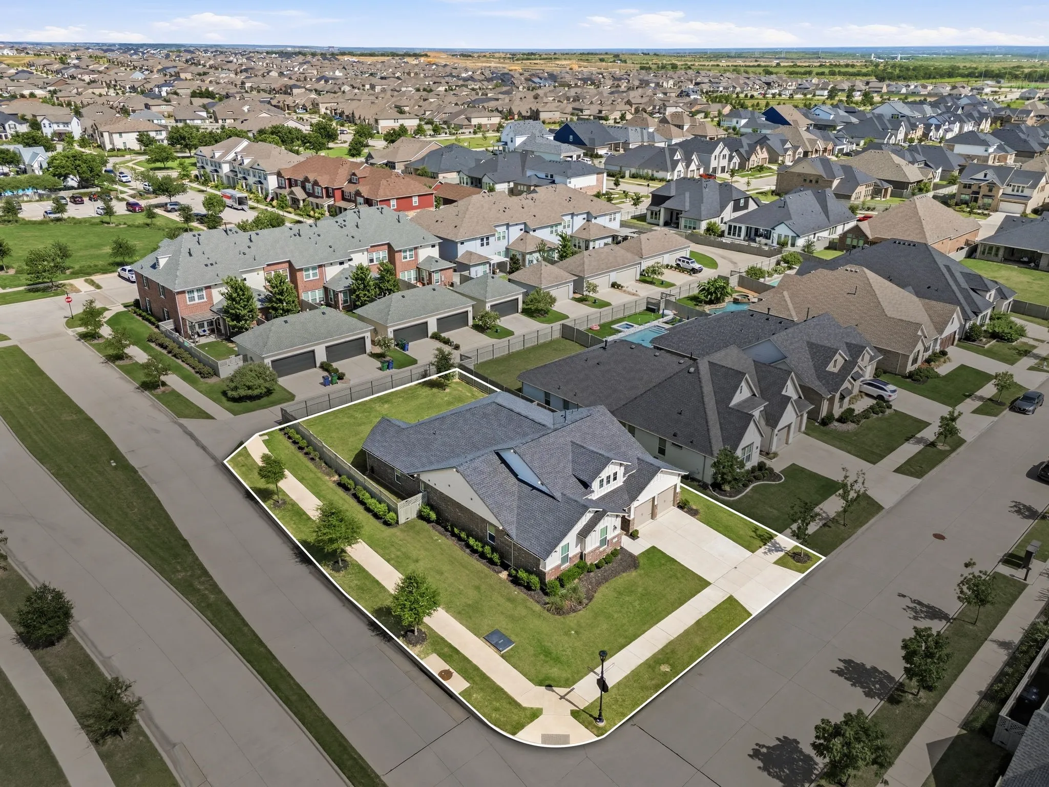 Aerial perspective highlighting the property's corner lot position and landscaped grounds