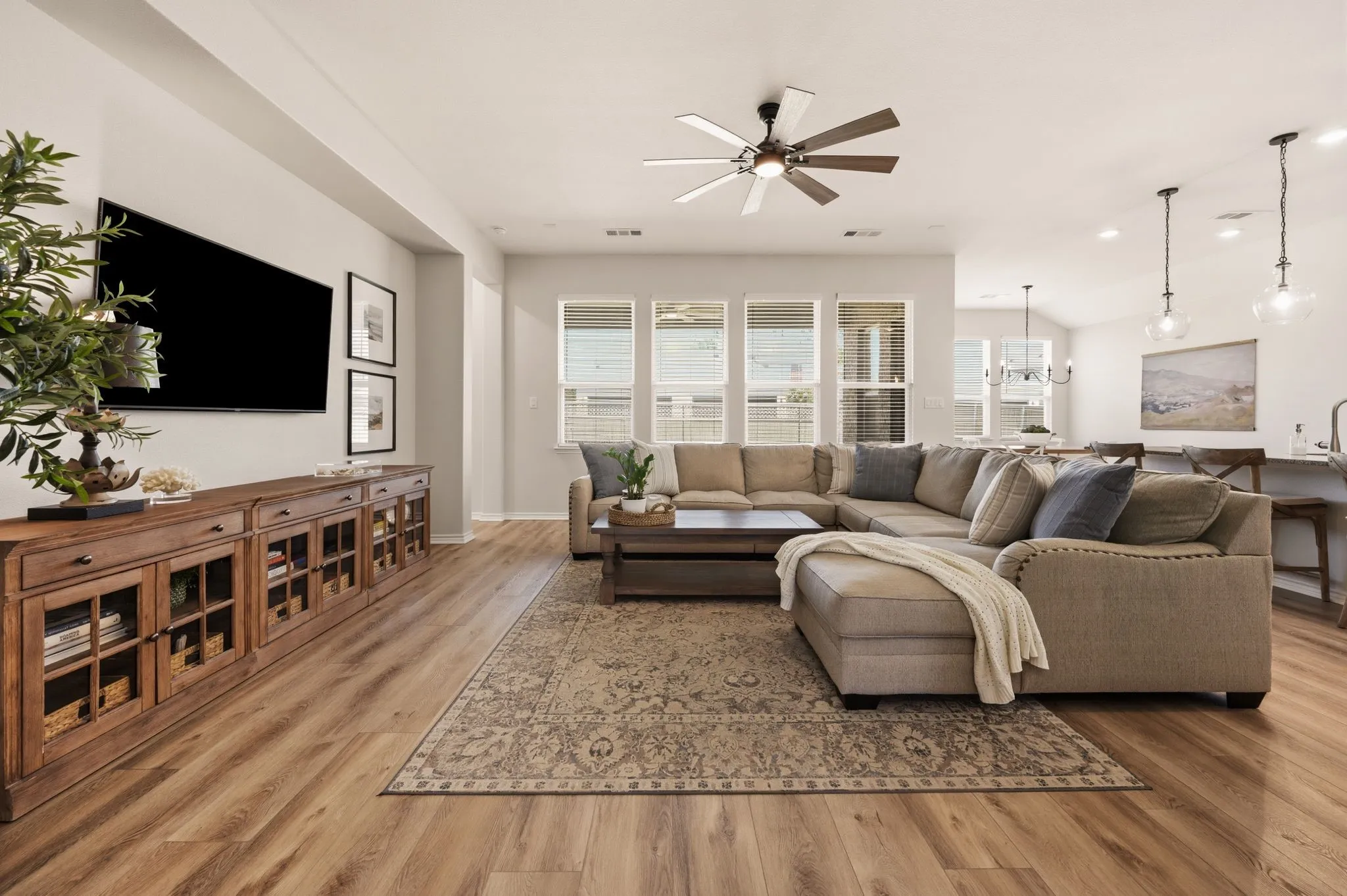 Spacious living area featuring High Quality LVP flooring, updated ceiling fan, recessed lighting and all the space you need to entertain!