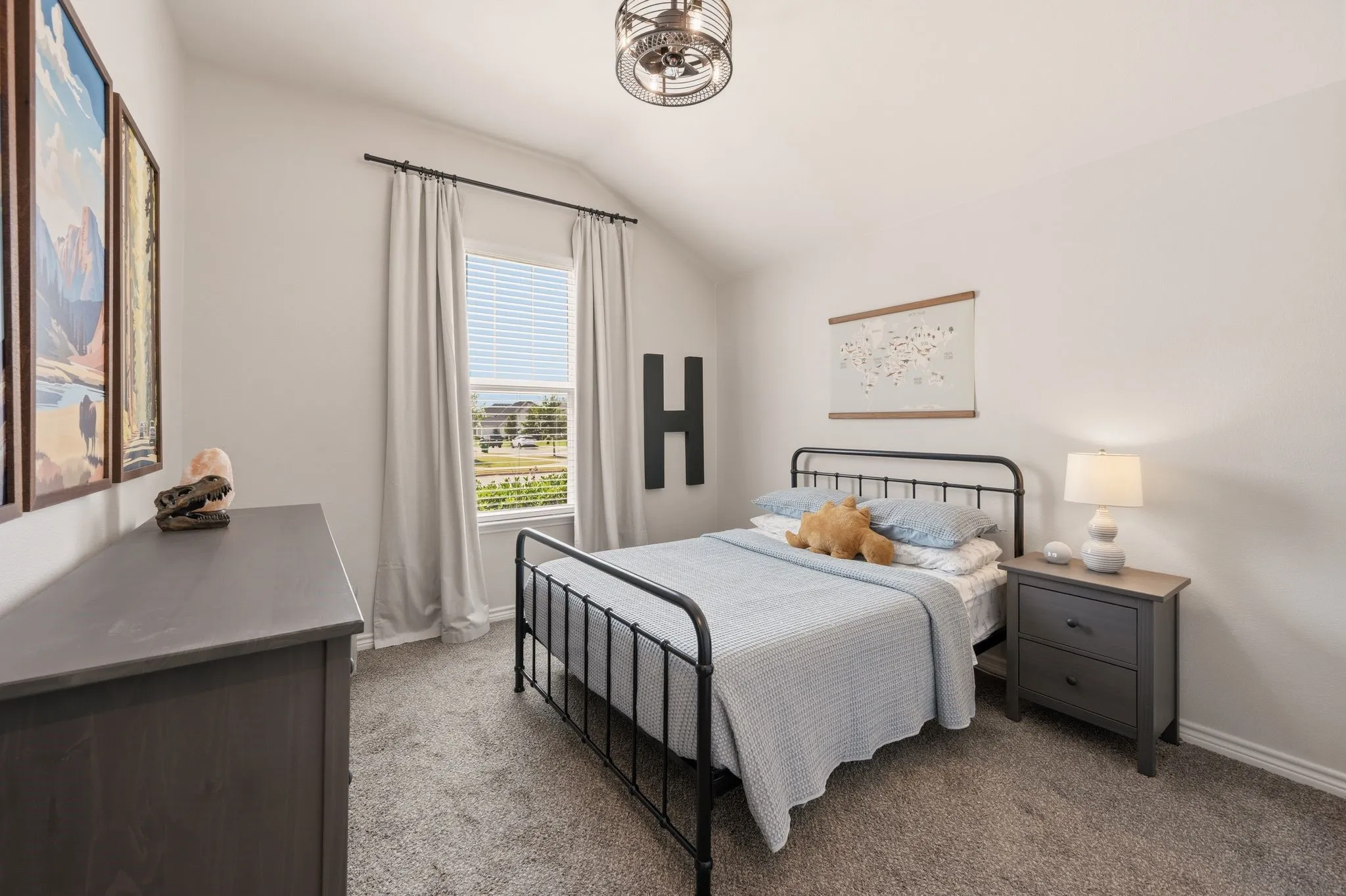 Carpeted room featuring a vaulted ceiling and a ceiling fan with integrated lighting