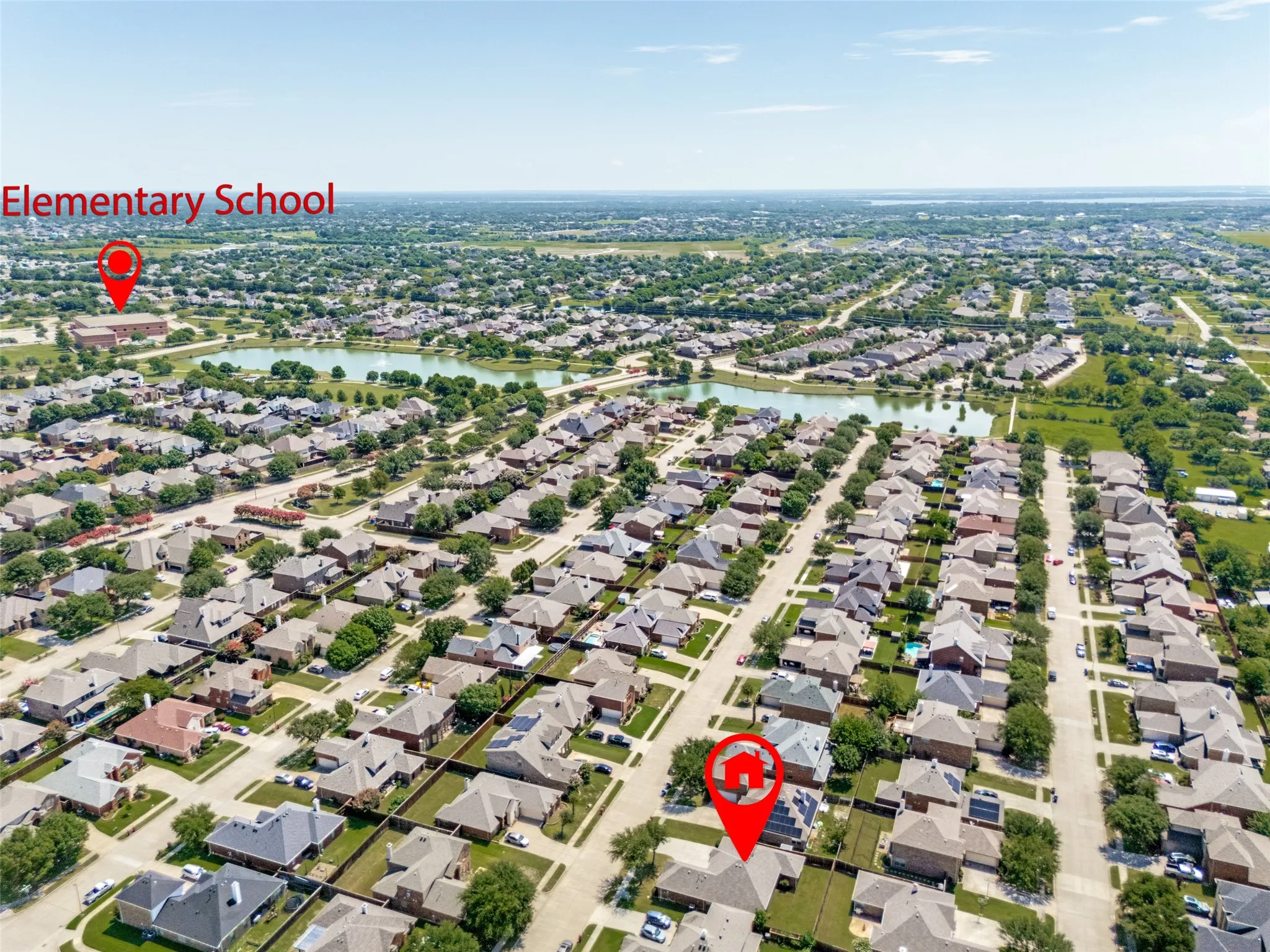 Aerial perspective showcasing a residential development with numerous single-family homes, tree-lined streets, and a central​​‌​​​​‌​​‌‌​‌‌​​​‌‌​‌​‌​‌​​​‌​​ pond