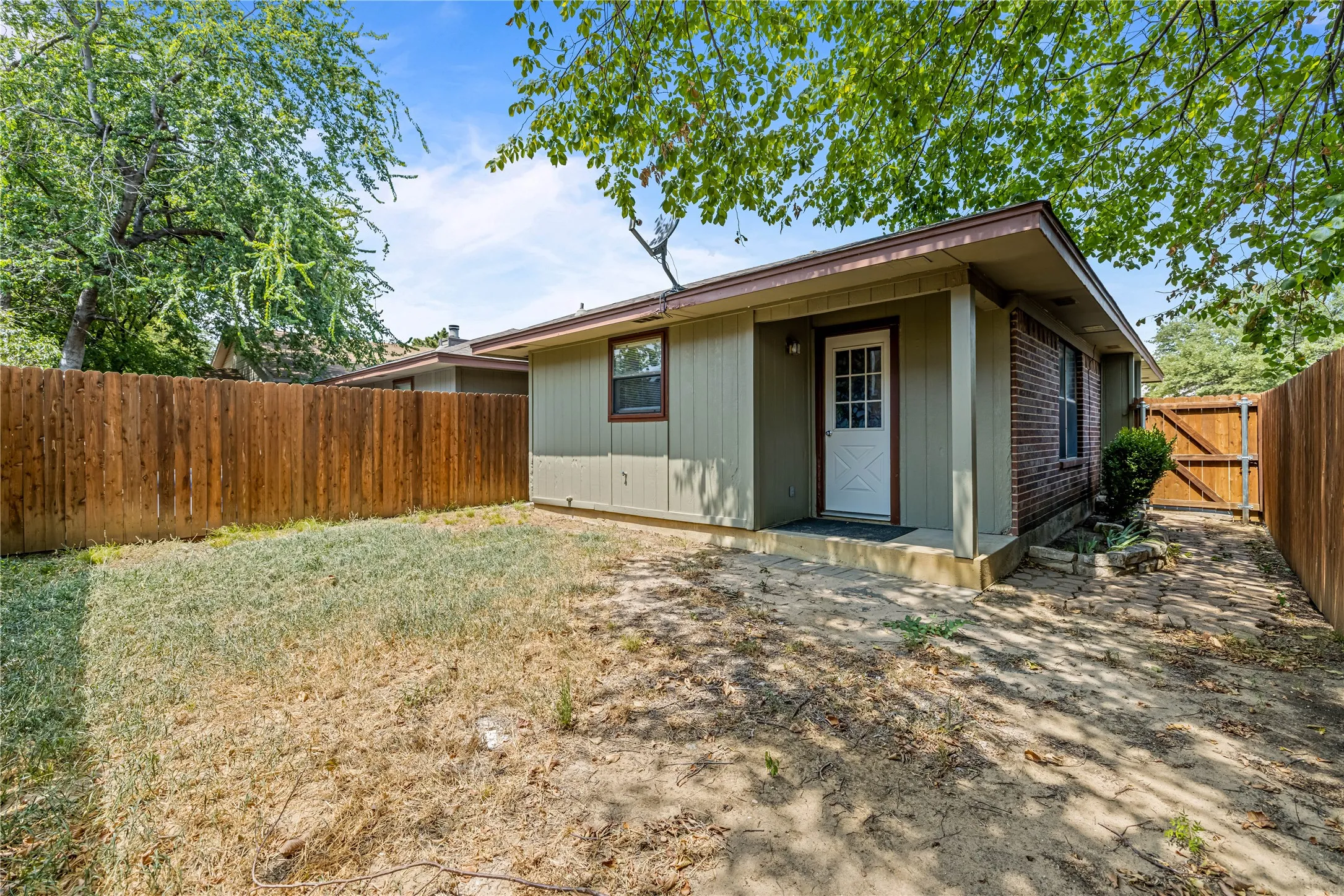 Rear view of house featuring a fenced backyard and a gate