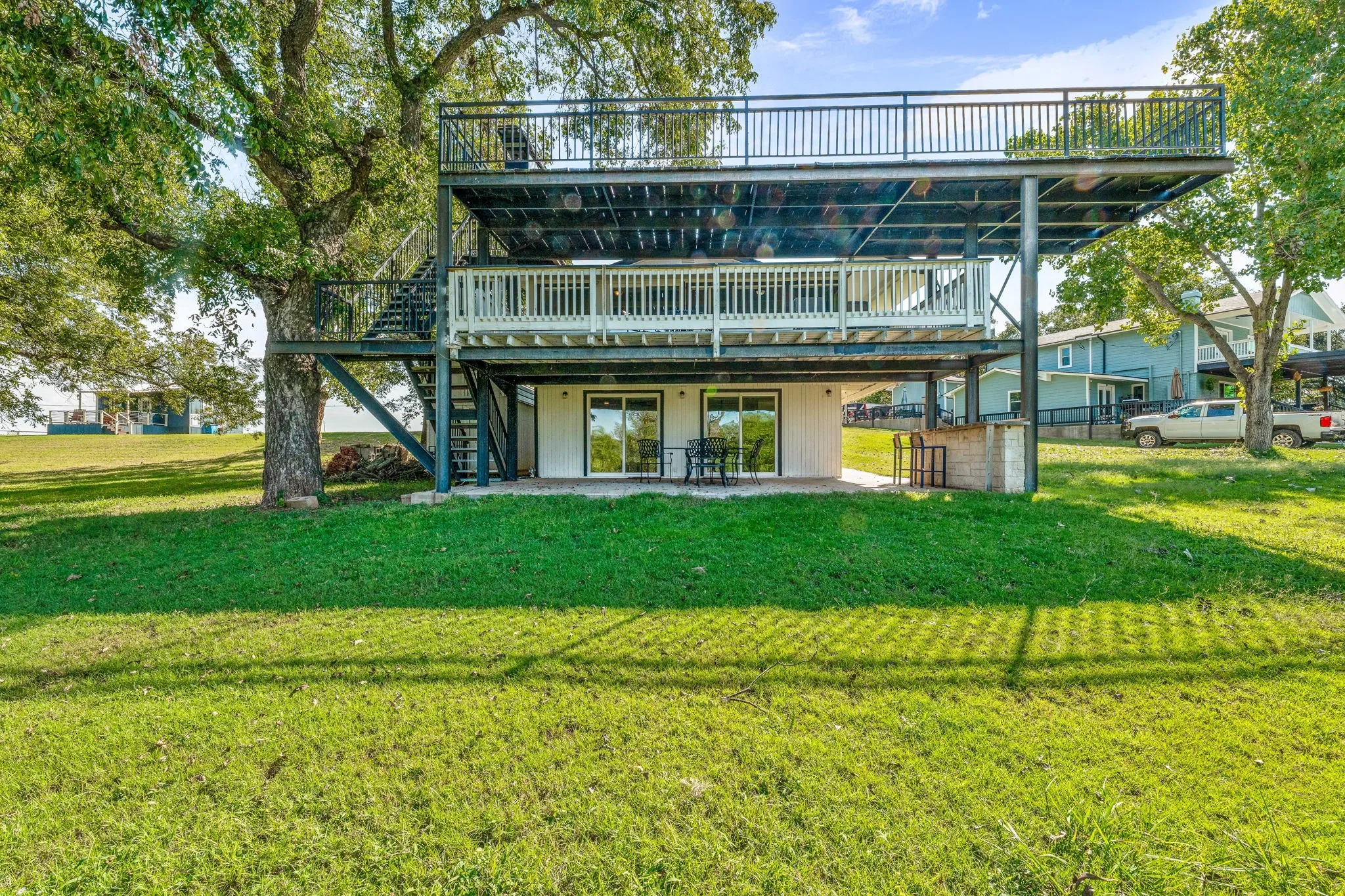 Back of house with a deck, a patio area, stairway, and a lawn