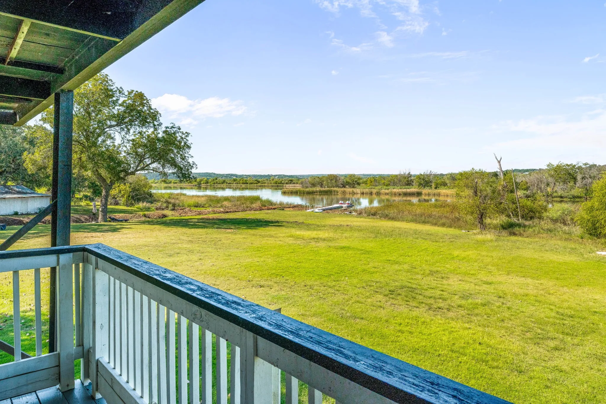 View of green lawn featuring a water view and a balcony