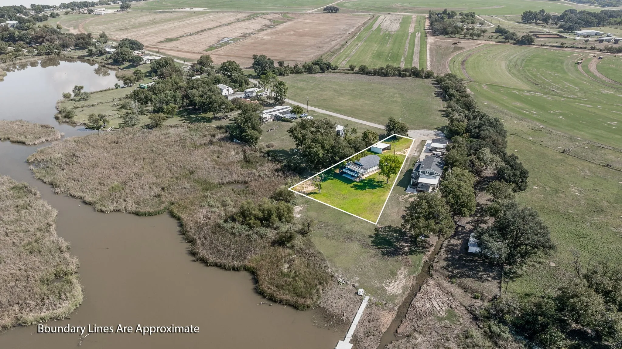 Overview of rural landscape featuring property parcel outlined and a nearby body of water
