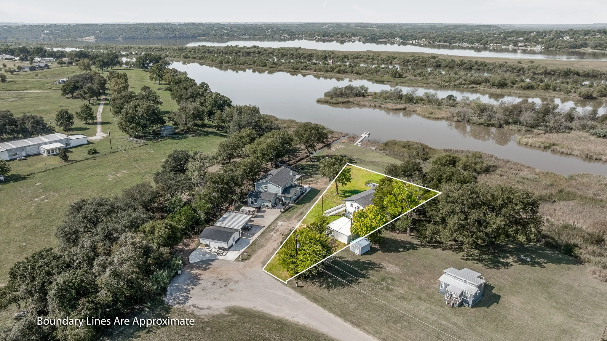 Aerial overview of property's location with a large body of water and property parcel outlined