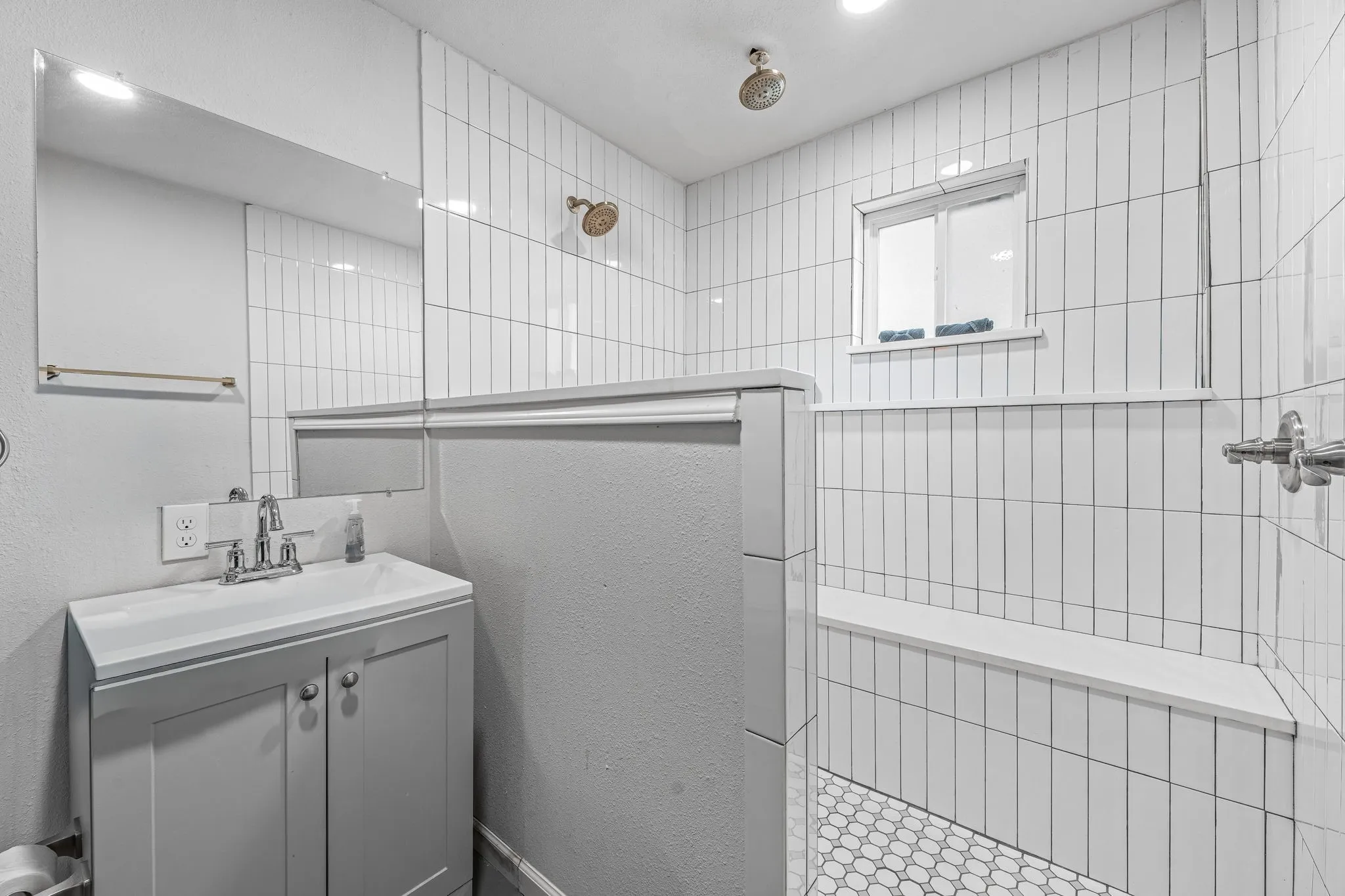 Bathroom featuring a walk in shower and vanity