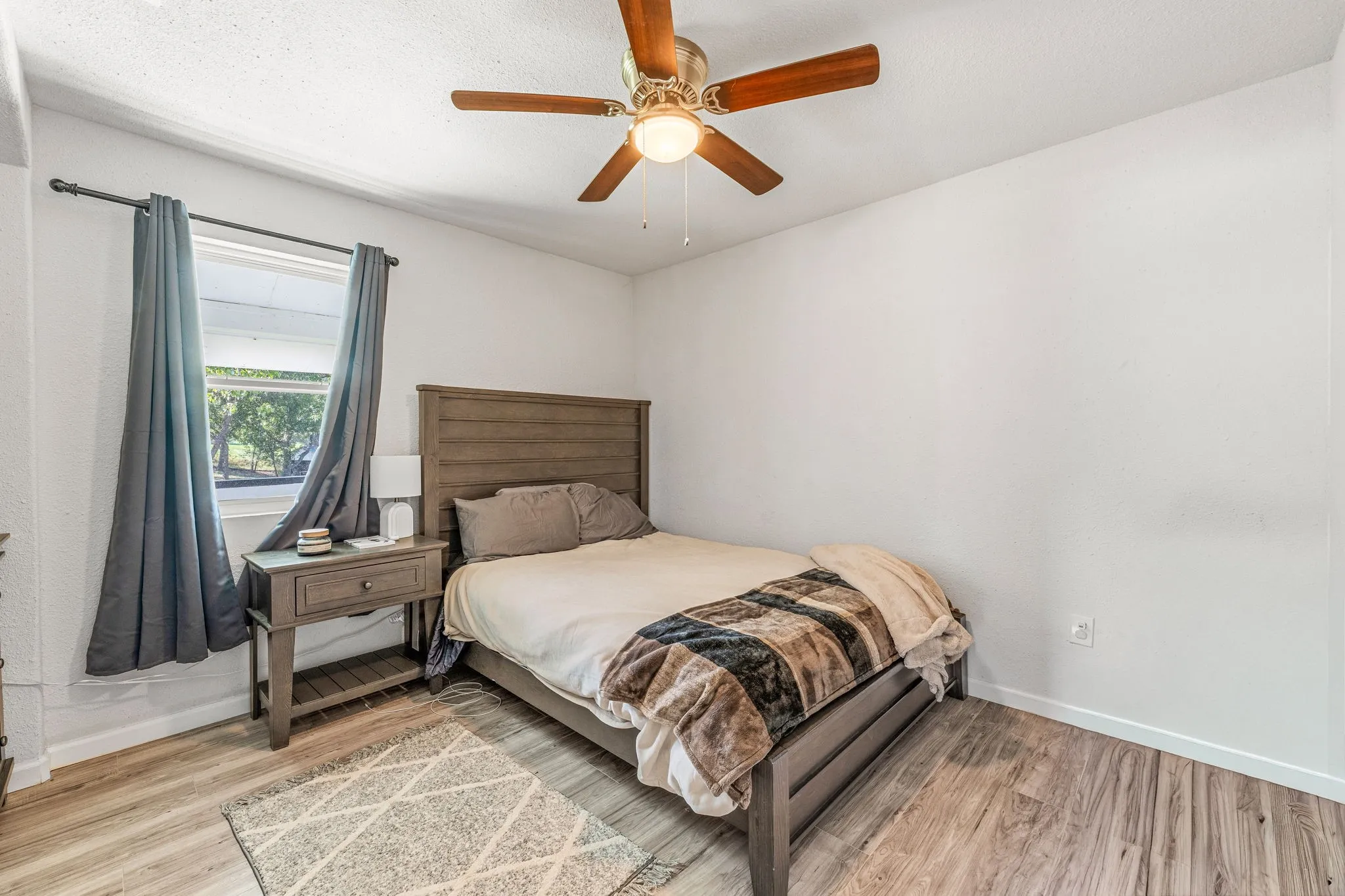 Bedroom with light wood finished floors and a ceiling fan