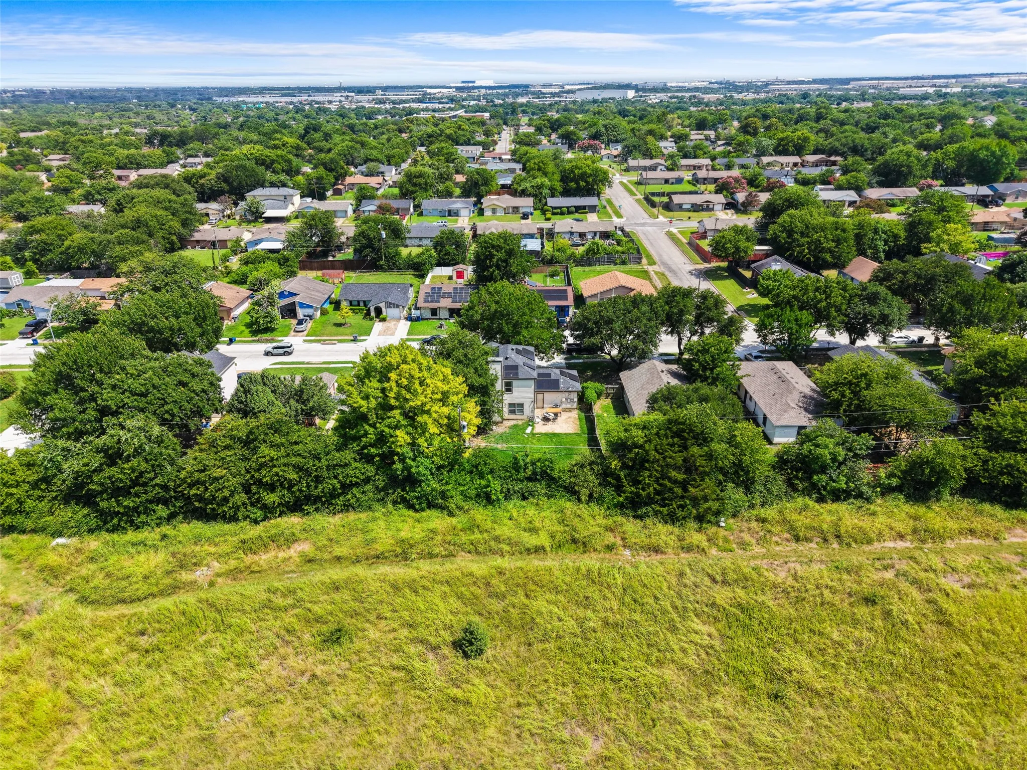 Expansive residential neighborhood featuring abundant mature trees and a clear blue sky