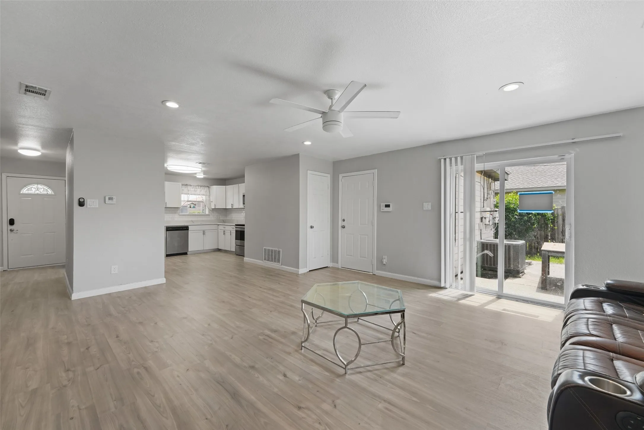 Open-concept living space featuring wood-finish flooring, recessed lighting, and a ceiling fan