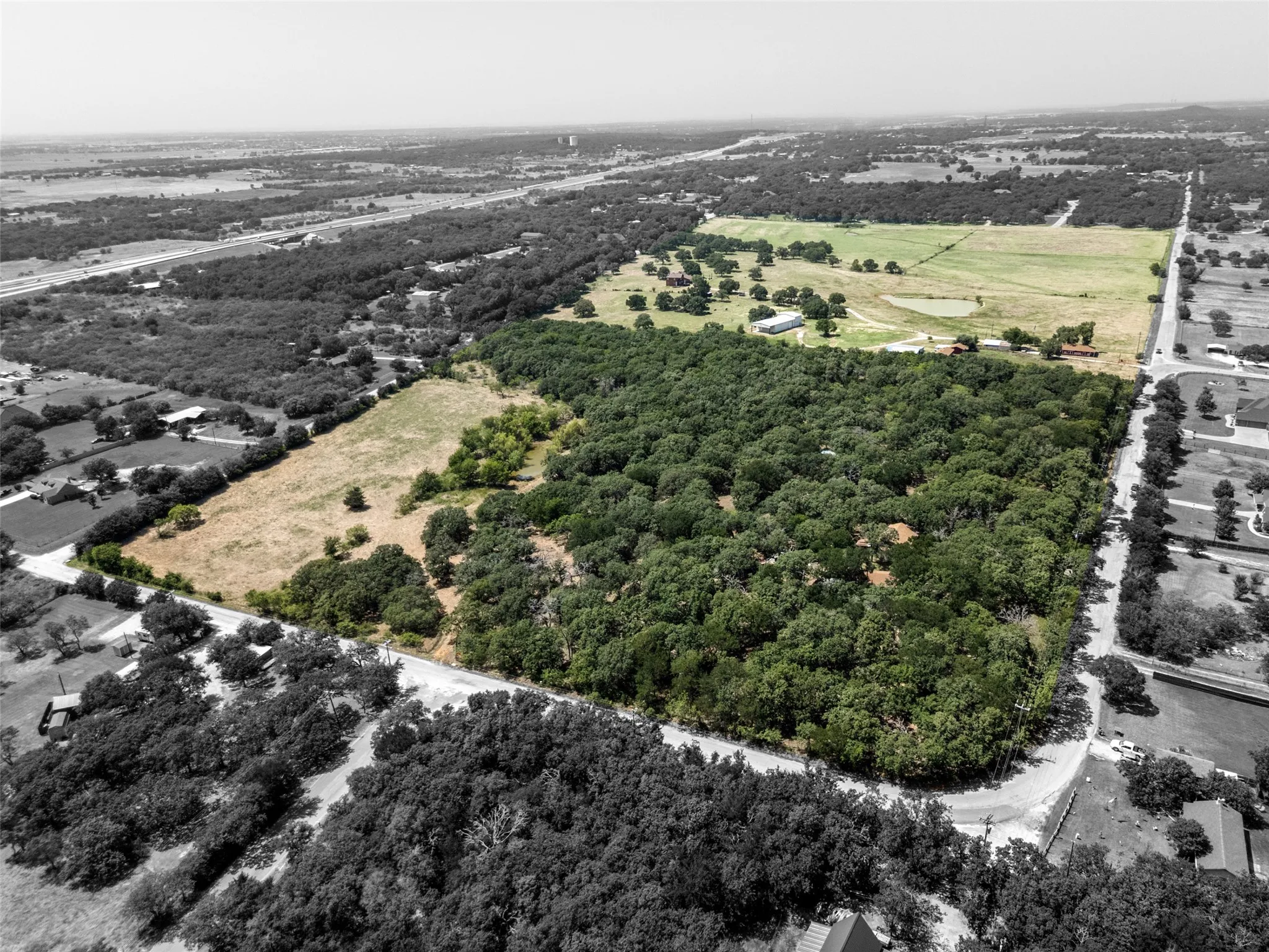 Expansive land parcel featuring significant tree coverage and open fields