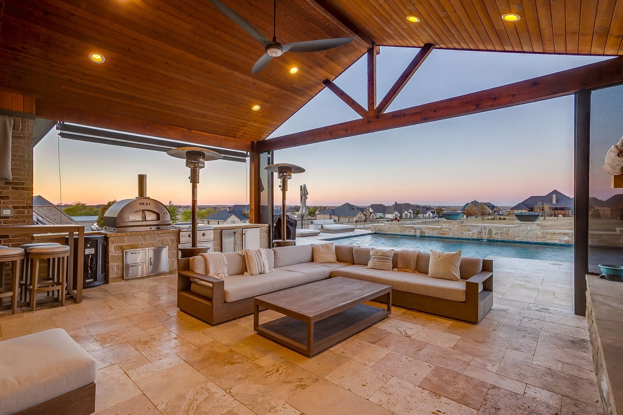 Large covered outdoor kitchen and seating area.  Travertine flooring.  Large pizza oven. Fireplace.  Outdoor heaters. Screens.