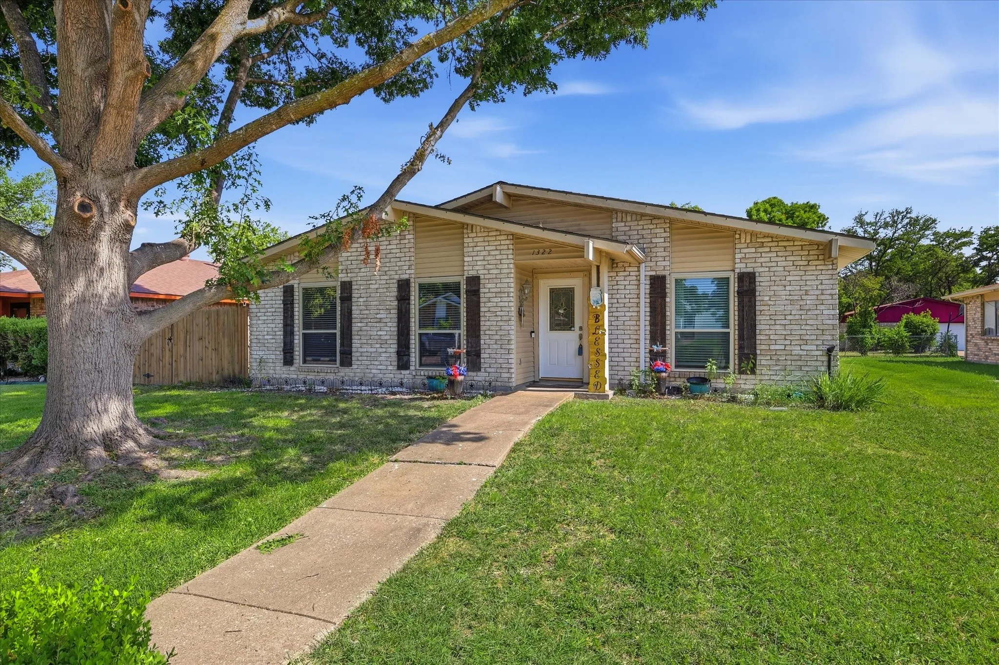 Beautiful mature tree and charming home and street.