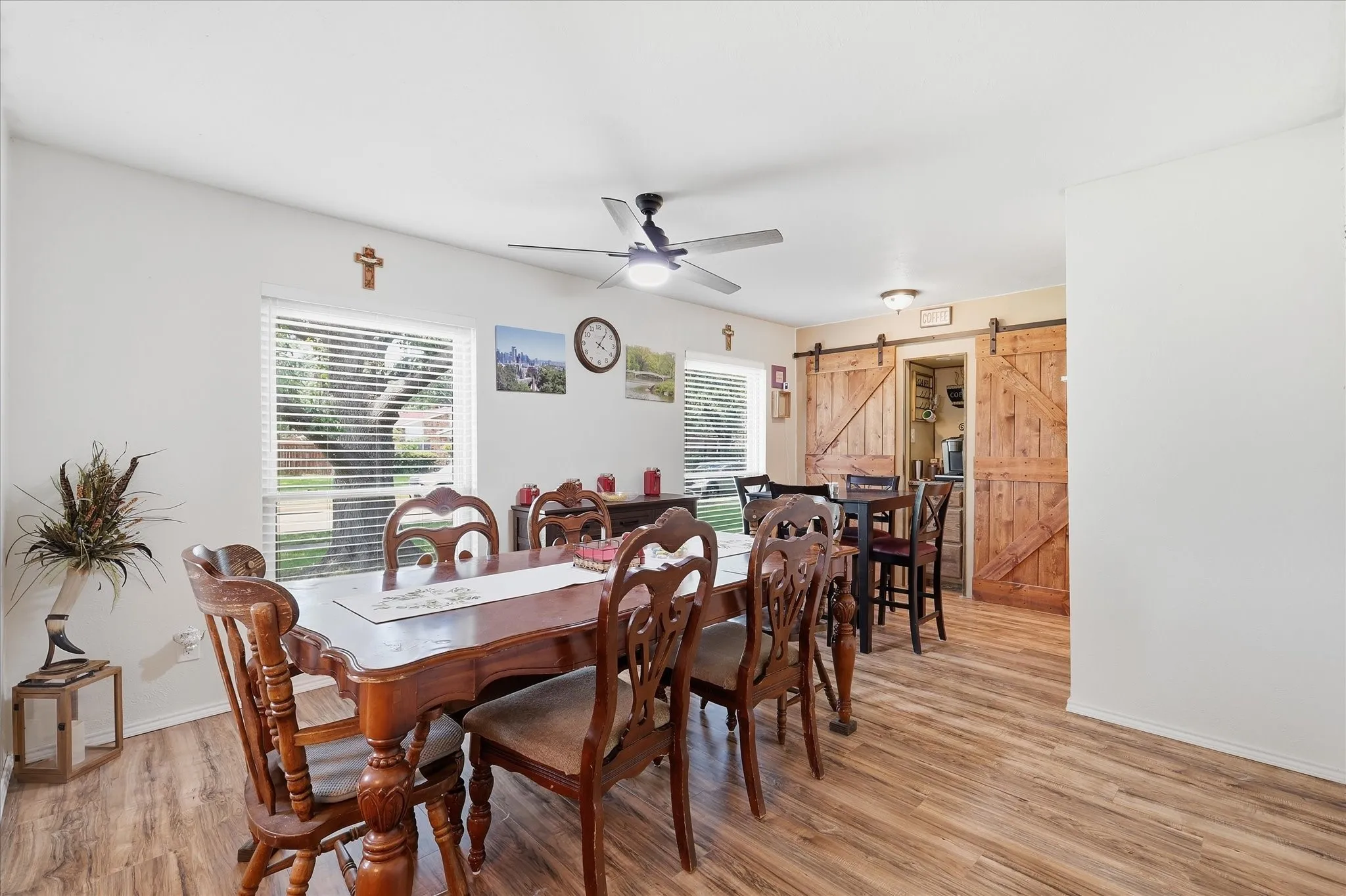 Integrated lighted coffee bar centered between dual barn door pantry spaces.