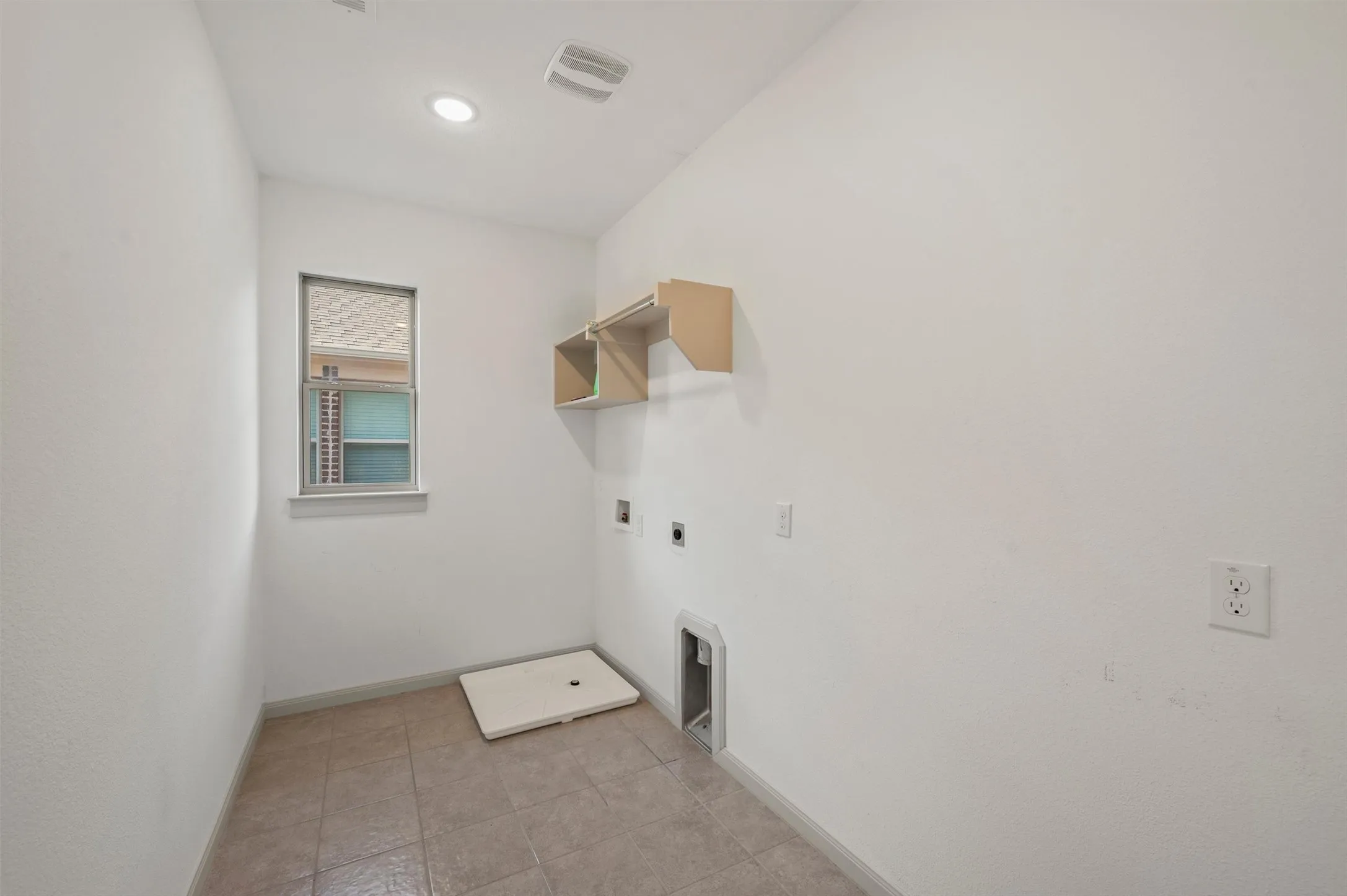 Recessed ceiling lighting, window with trim, wall-mounted shelving, and tile flooring