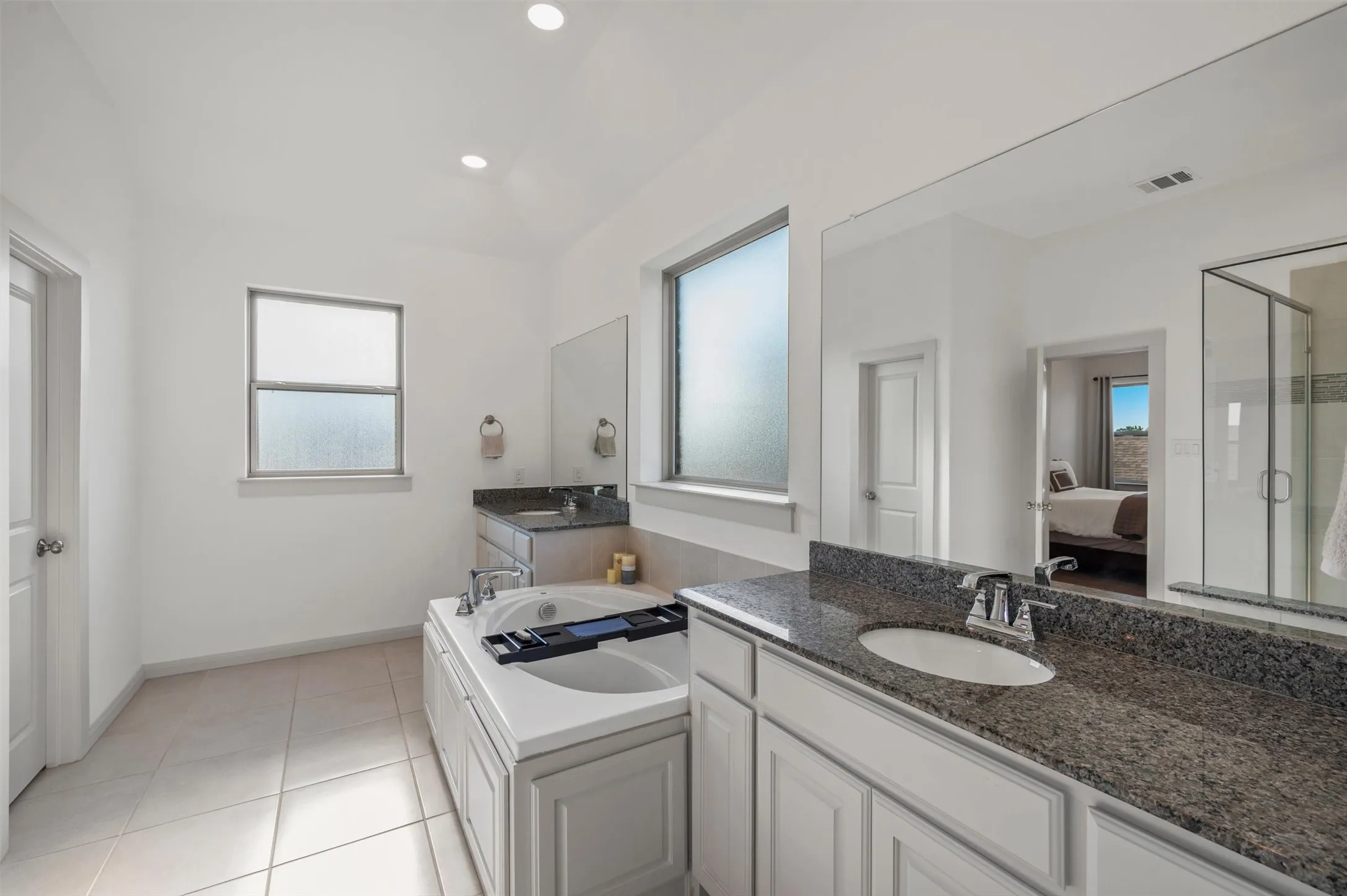 Dual vanity with granite countertops, undermount sinks, and chrome fixtures