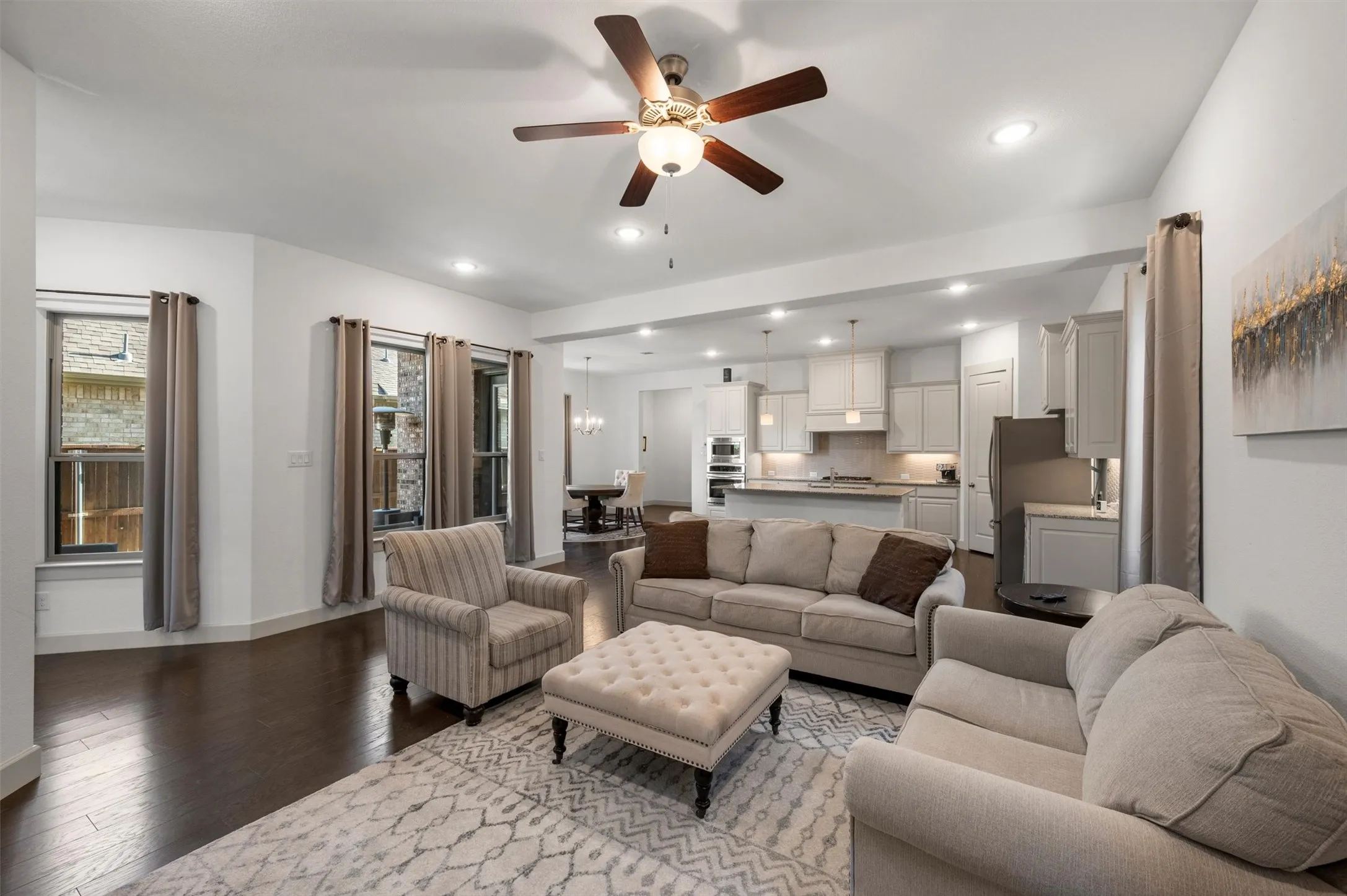 Open-concept living space featuring wood-finish flooring, recessed lighting, and a ceiling fan