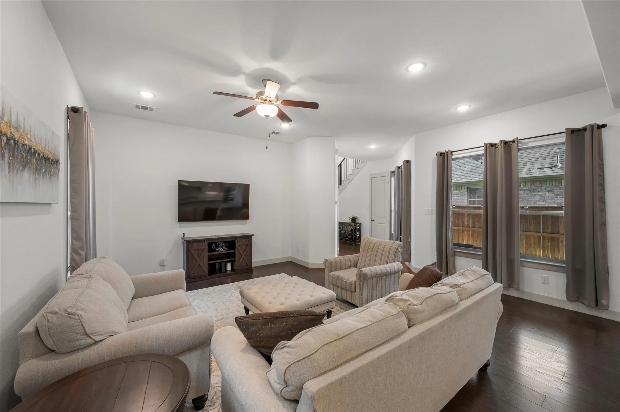 Recessed lighting, ceiling fan, wood-finish flooring, white walls, and multiple windows