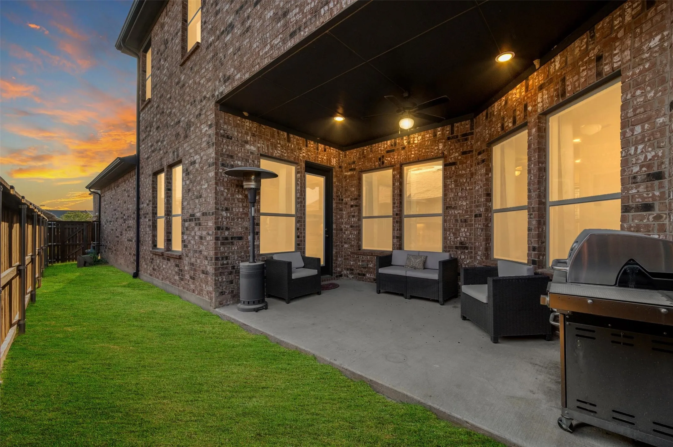 Brick exterior with a covered patio, concrete slab, recessed lighting, and a ceiling fan