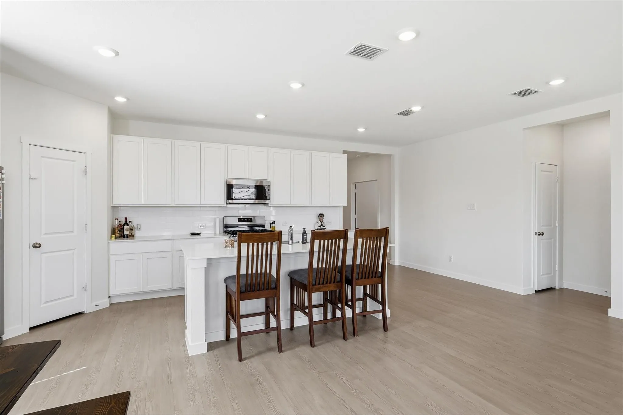 Open-concept kitchen and living area featuring wood-finish flooring