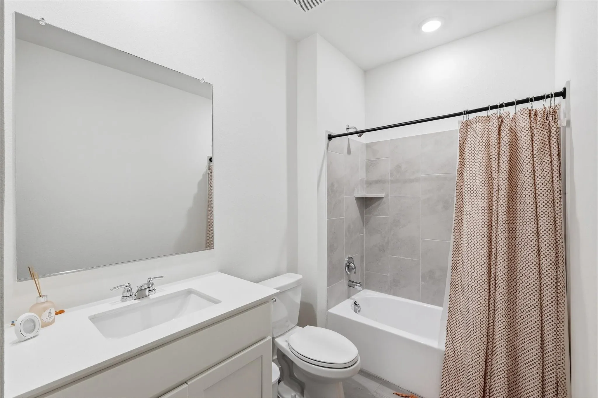 Bathroom featuring a bright white vanity with an integrated sink, polished chrome faucet, and a large wall-mounted mirror
