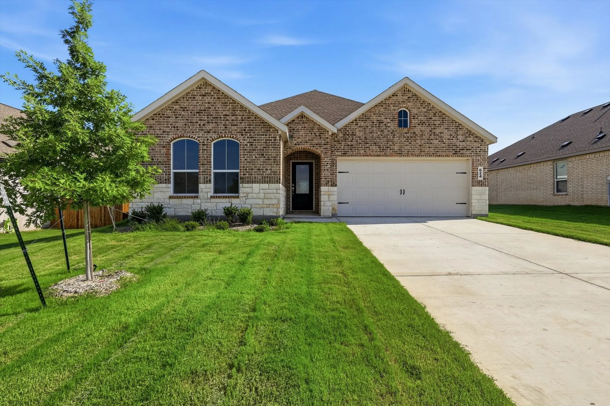 Brick facade with stone accents and a two-car garage