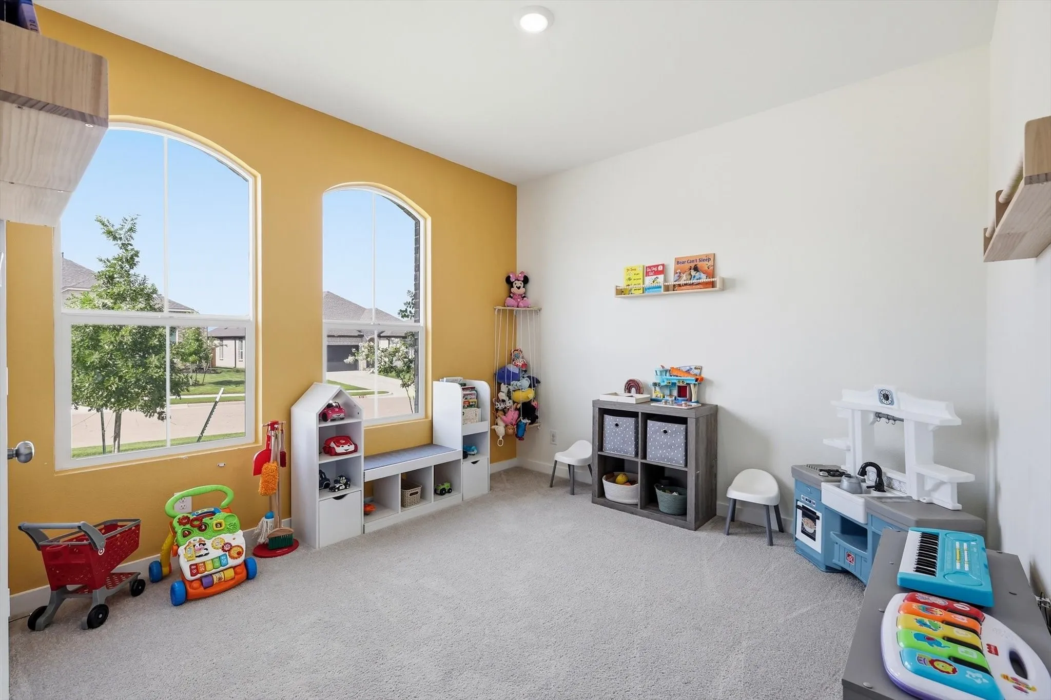 Spacious room featuring arched windows, soft carpeting, and recessed lighting