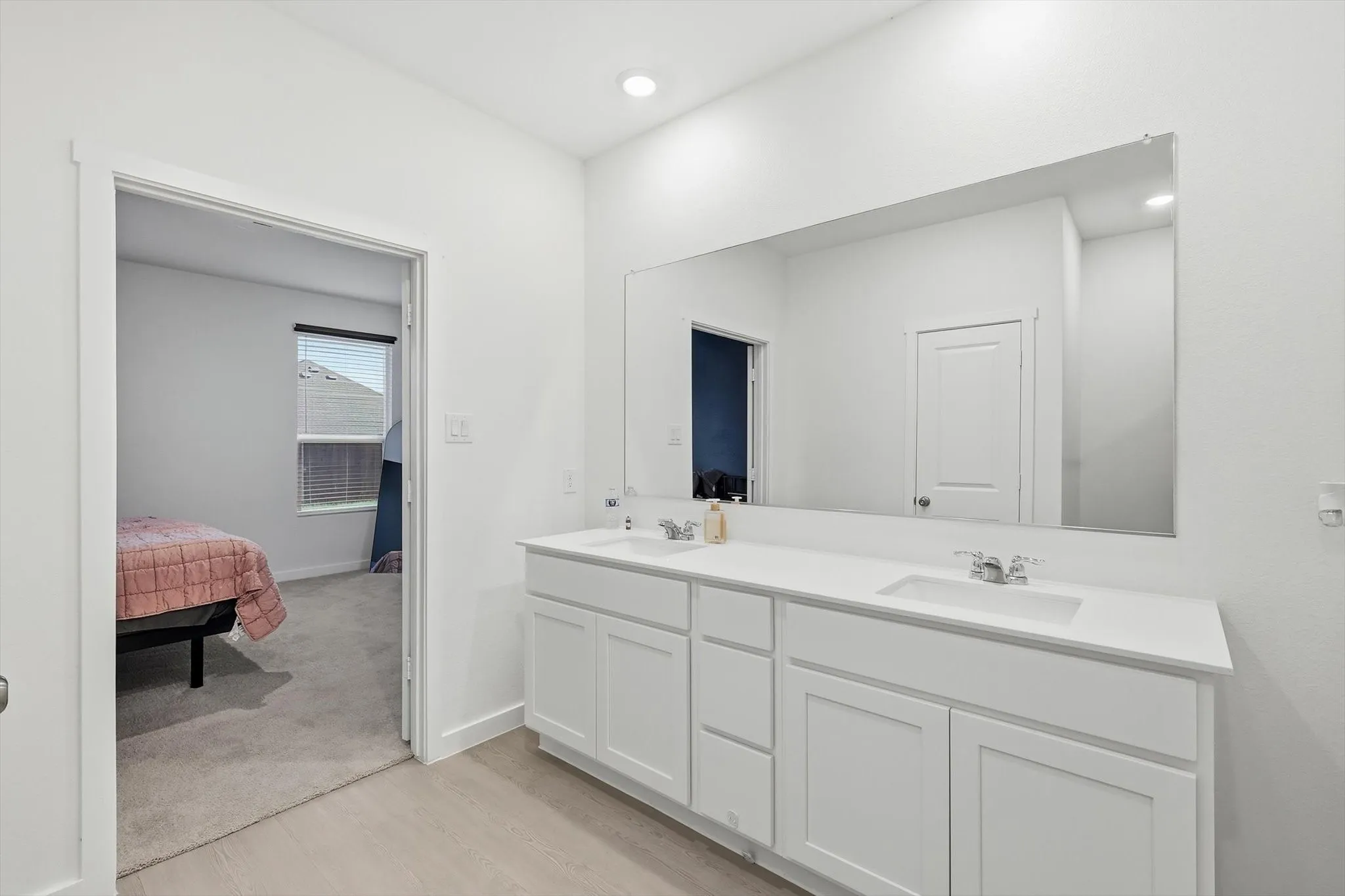 Dual vanity featuring two undermount sinks, chrome fixtures, and a white countertop