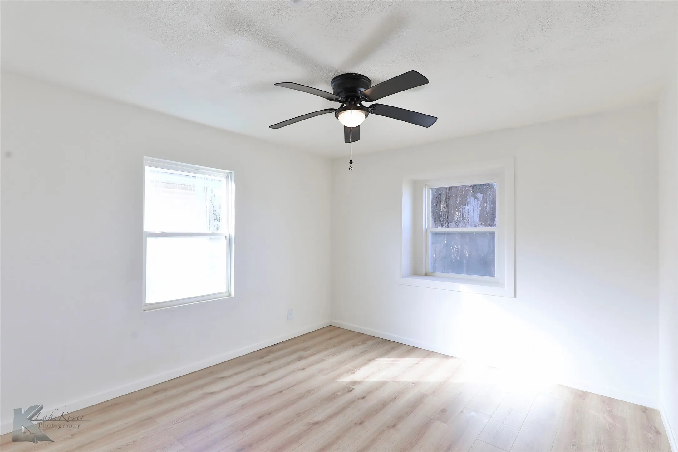 Bright interior space featuring light wood-finish flooring and crisp white walls