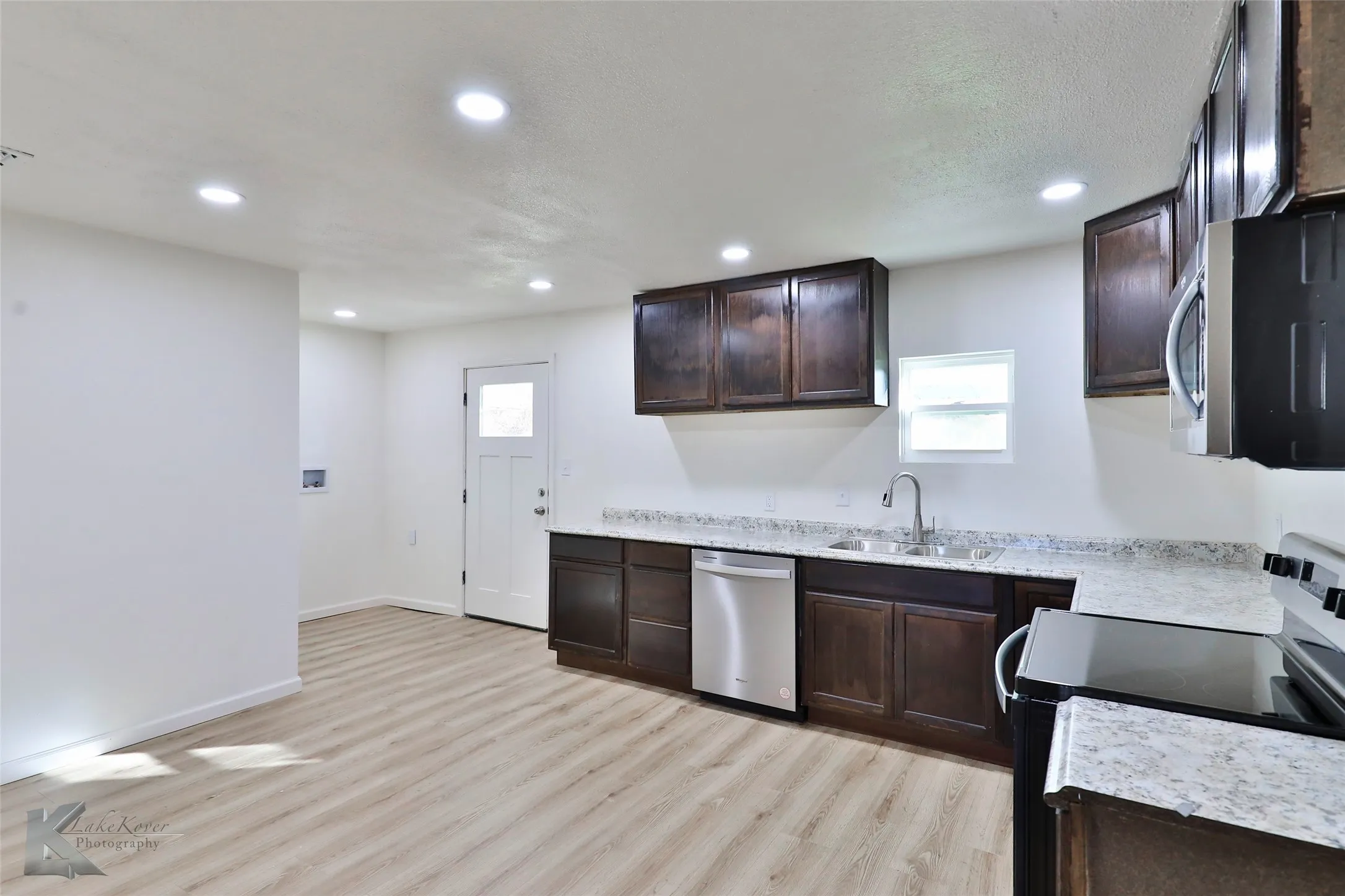 Kitchen featuring dark wood cabinetry, light-toned countertops, and wood-finish flooring