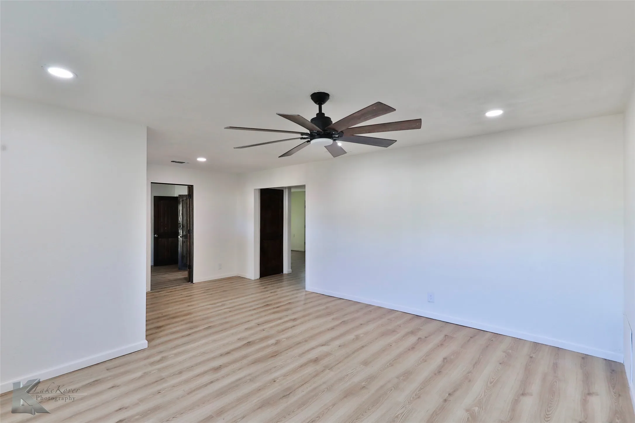 Spacious room featuring wood-finish flooring, recessed lighting, and a contemporary ceiling fan