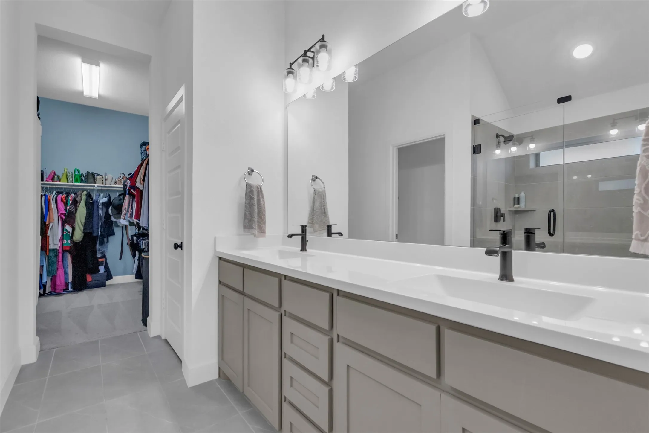 Bathroom featuring a dual vanity with light gray cabinetry, white countertops, and integrated rectangular sinks