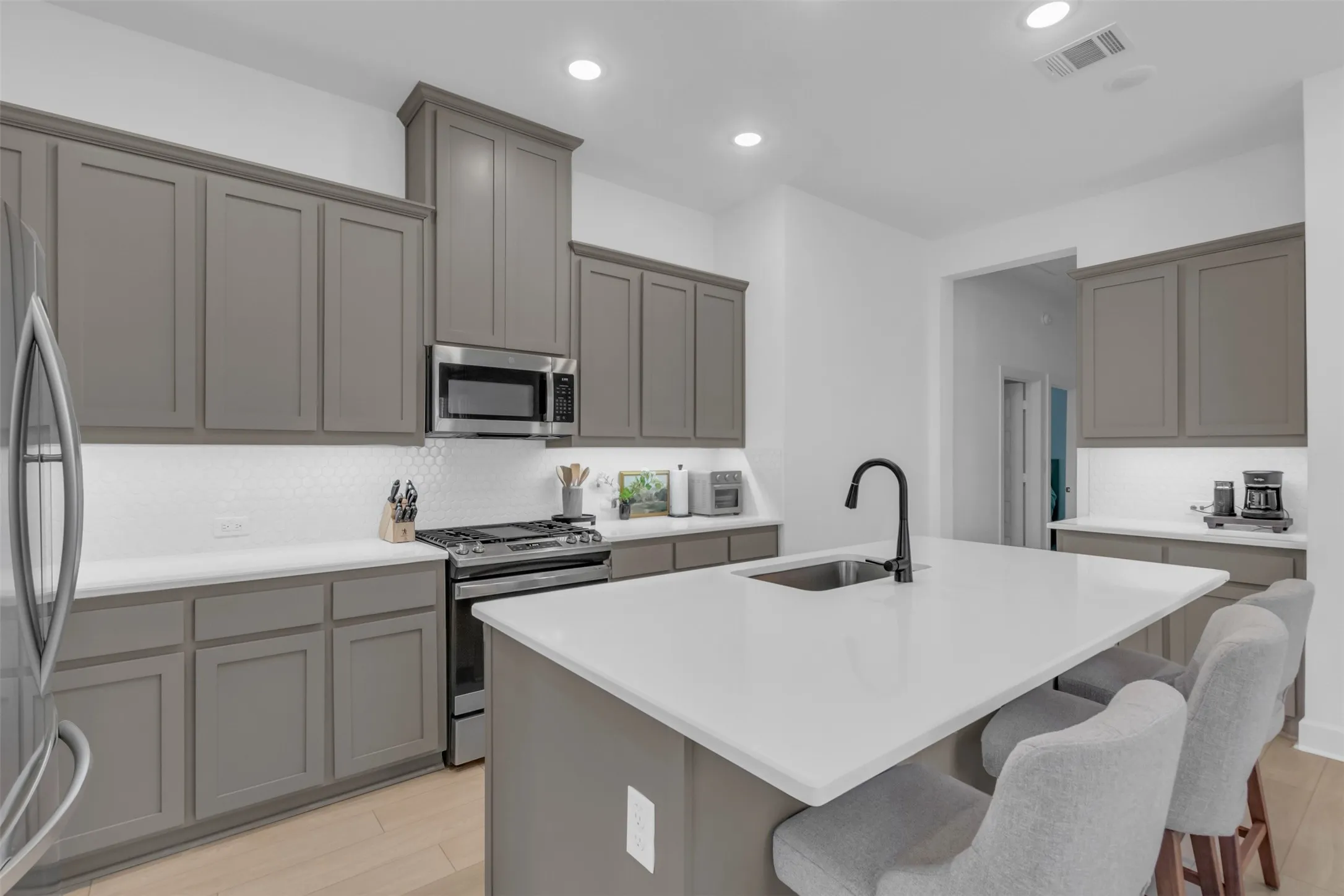 Kitchen featuring an expansive island with an undermount sink and a matte black faucet