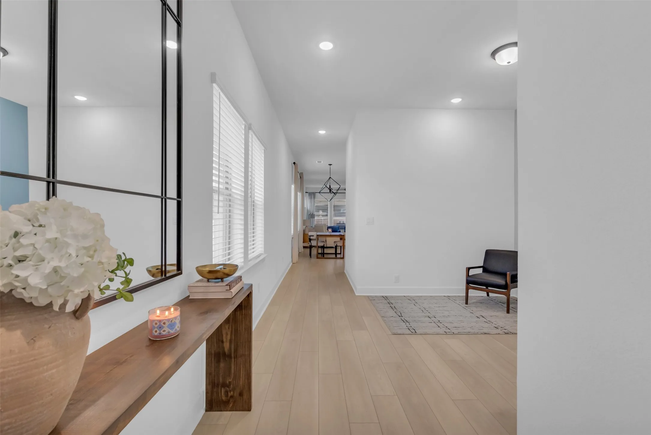 Entryway featuring light wood-finish flooring, recessed lighting, and multiple windows with blinds