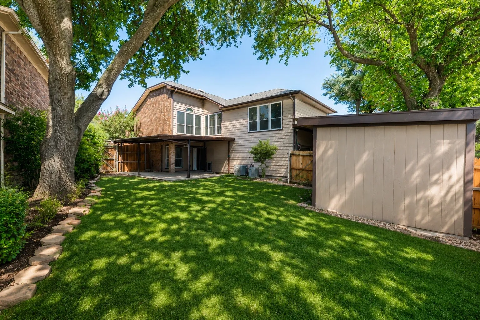 Expansive lawn area featuring mature trees providing natural shade