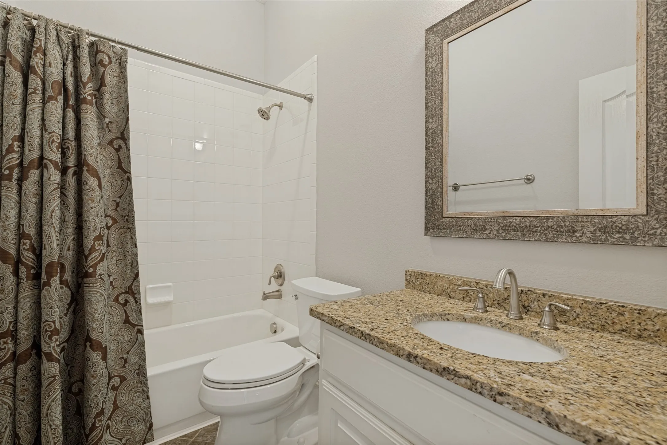 White vanity with a granite countertop and undermount sink