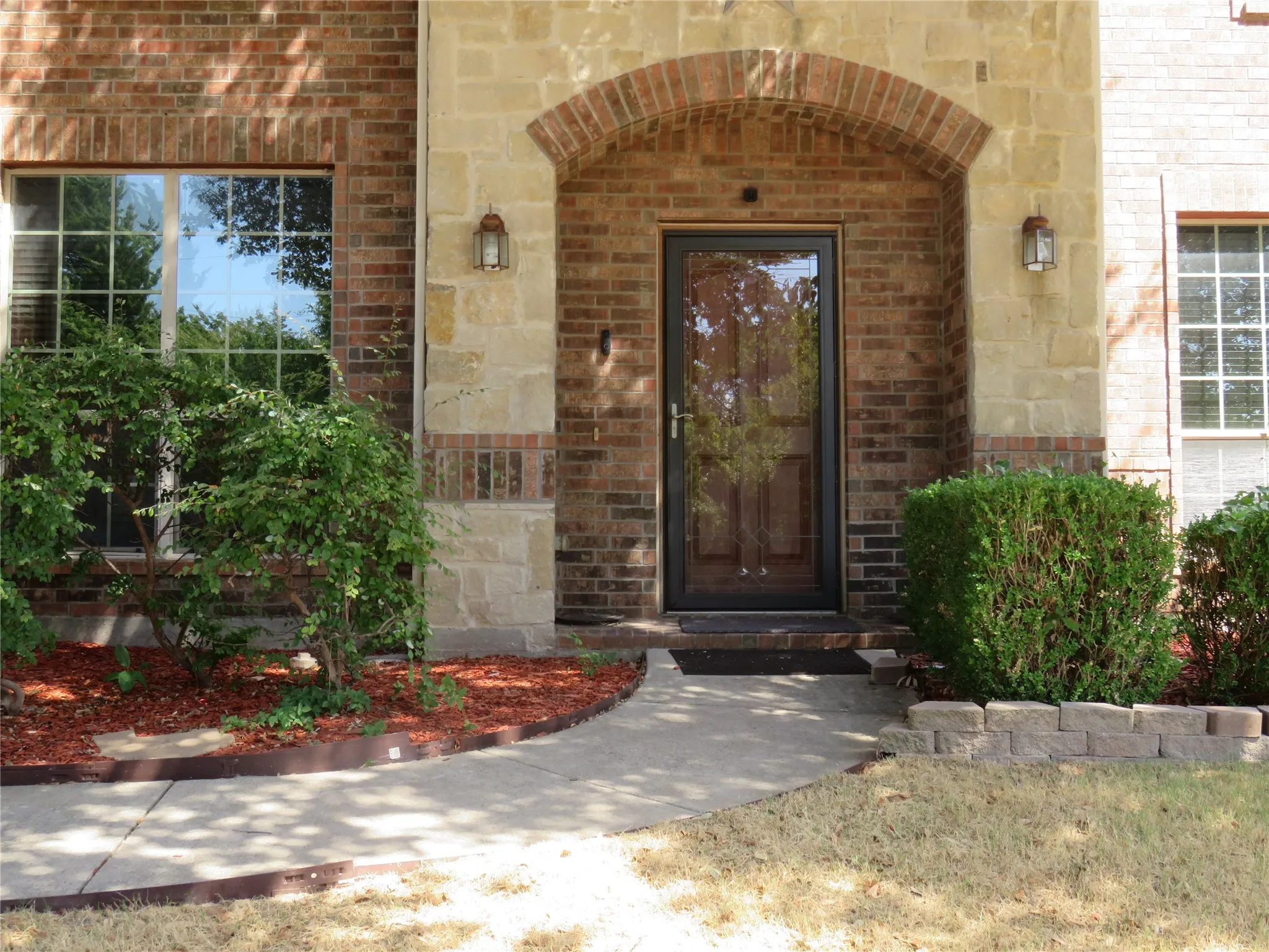 Brick and stone facade featuring an arched entryway