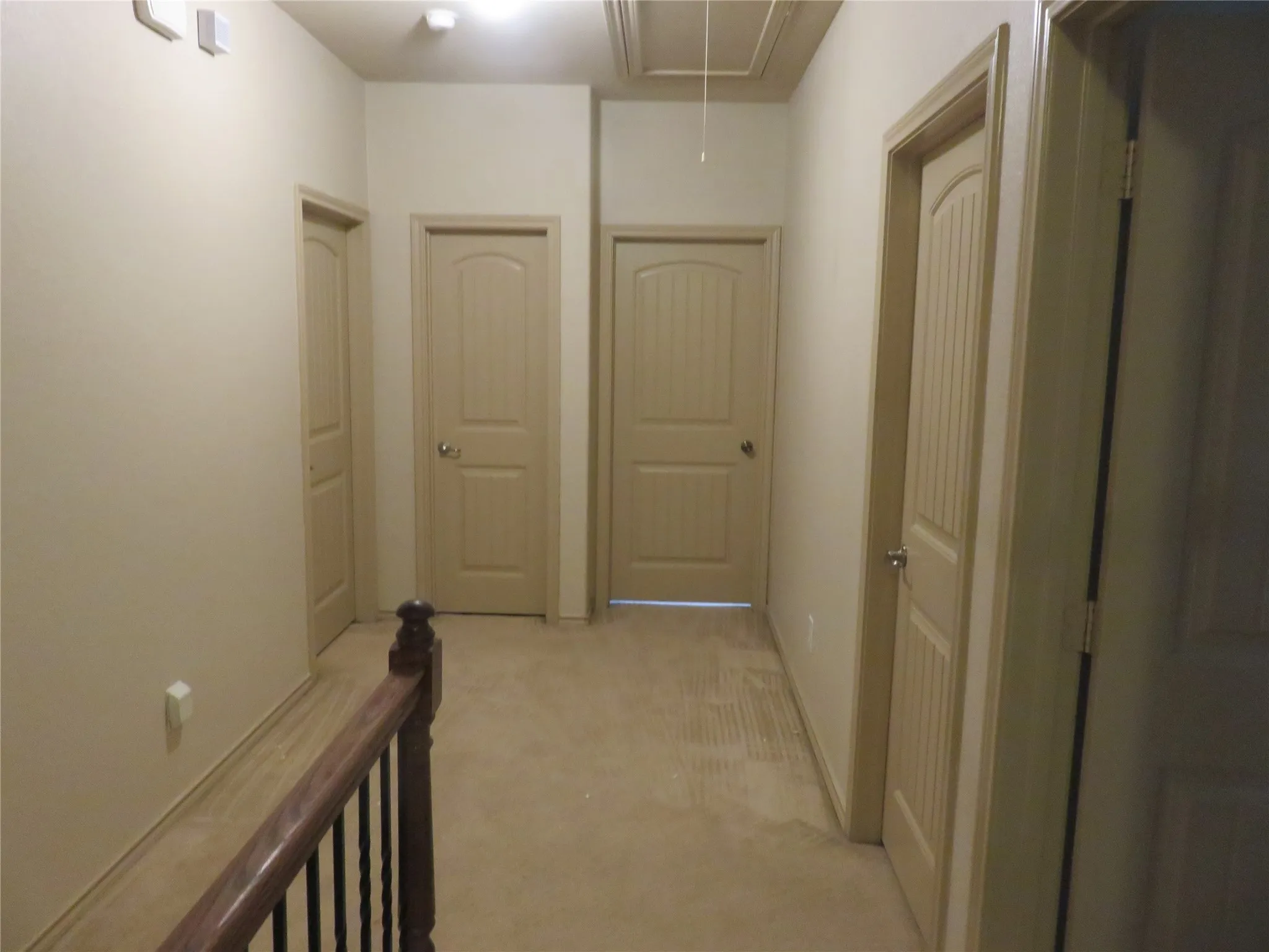 Hallway featuring neutral wall tones and beige carpeted flooring