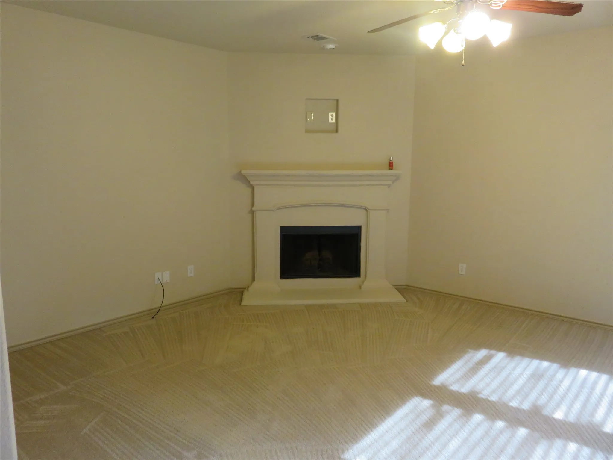 Built-in corner fireplace with a classic mantel, dark firebox, and hearth